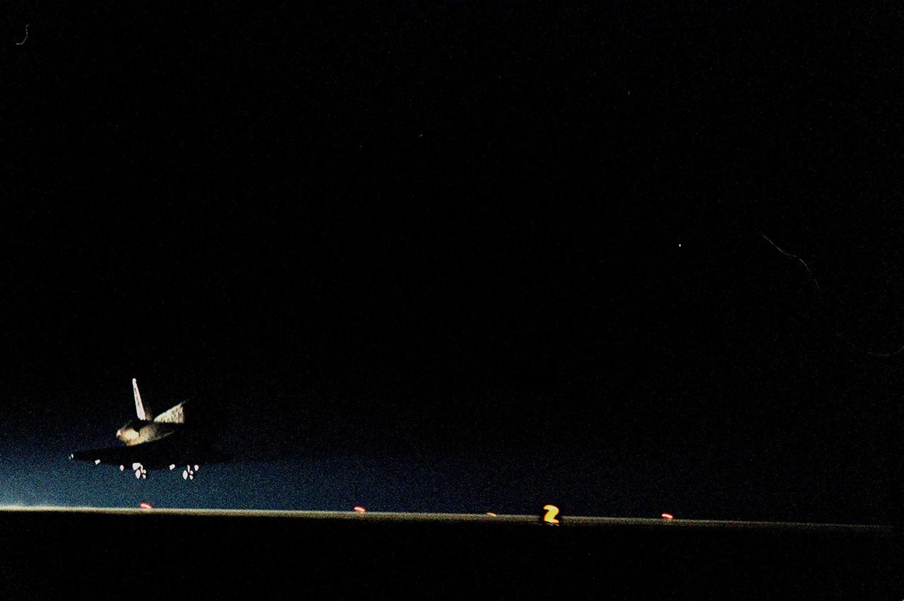 KENNEDY SPACE CENTER, Fla. -- The Space Shuttle Discovery drops out of the darkness onto runway 33 at the Shuttle Landing Facility after traveling more than 3,267,000 miles on a successful eight-day mission to service the Hubble Space Telescope. Astronauts Curtis L. Brown Jr., Commander; Scott J. Kelly, Pilot; and Steven L. Smith, C. Michael Foale (Ph.D.), John M. Grunsfeld (Ph.D.), Claude Nicollier of Switzerland and Jean-François Clervoy of France, all Mission Specialists, spent the Christmas holiday in space in order to accomplish their mission before the end of 1999. During the mission, Discovery's four space-walking astronauts, Smith, Foale, Grunsfeld and Nicollier, spent 24 hours and 33 minutes upgrading and refurbishing Hubble, making it more capable than ever to renew its observations of the universe. Mission objectives included replacing gyroscopes and an old computer, installing another solid state recorder, and replacing damaged insulation in the telescope. Hubble was released from the end of Discovery's robot arm on Christmas Day. Main gear touchdown was at 7:00:47 p.m. EST. Nose gear touchdown occurred at 7:00:58 p.m. EST and wheel stop at 7:01:34 p.m. EST. This was the 96th flight in the Space Shuttle program and the 27th for the orbiter Discovery. The landing was the 20th consecutive Shuttle landing in Florida and the 13th night landing in Shuttle program history