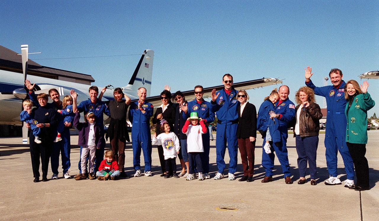 The STS-103 crew pose for a group portrait with their families and loved ones on the runway at Patrick Air Force Base. They are preparing to board an airplane that will return them to their home base at the Johnson Space Center in Houston following the successful completion of their mission. From left to right, the crew members are Mission Specialists John M. Grunsfeld (Ph.D.), C. Michael Foale (Ph.D.), Claude Nicollier of Switzerland, Jean-François Clervoy of France, and Steven L. Smith; Pilot Scott J. Kelly; and Commander Curtis L. Brown Jr. Discovery landed in darkness the previous evening, Dec. 27, on runway 33 at KSC's Shuttle Landing Facility at 7:00:47 p.m. EST. This was the first time that a Shuttle crew spent the Christmas holiday in space. The STS-103 mission supplied the Hubble Space Telescope with six new gyroscopes, six new voltage/temperature improvement kits, a new onboard computer, a new solid state recorder and new data transmitter, and a new fine guidance sensor along with new insulation on parts of the orbiting telescope. This was the 96th flight in the Space Shuttle program and the 27th for the orbiter Discovery