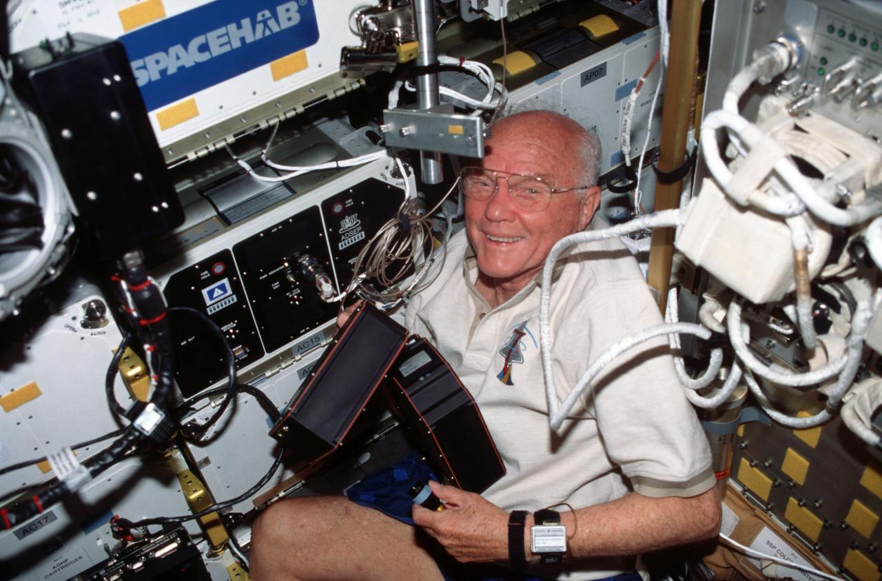 Oct. 1998 -- STS-95 payload specialist John Glenn removes the Advanced Organic Separation (ADSEP) cartridges and moves them to the Spacehab module.