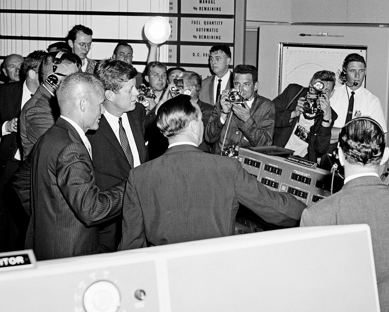 CAPE CANAVERAL Fla. -- Photojournalists crowd in as astronaut John H. Glenn Jr., left, talks to President John F. Kennedy about a console in the Mercury Control Center at the Cape Canaveral Missile Test Annex in Florida. Photo Credit: NASA