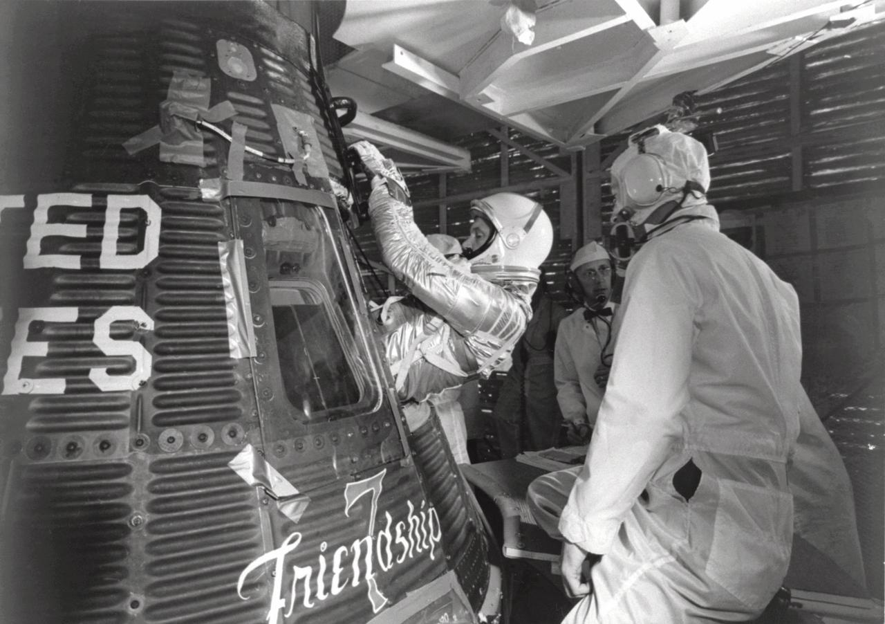 CAPE CANAVERAL, Fla. -- Astronaut John H. Glenn Jr. enters his Mercury capsule, "Friendship 7," as he prepares for launch of the Mercury-Atlas rocket. On February 20, 1962, Glenn lifted off into space aboard his Mercury Atlas 6 MA-6 rocket and became the first American to orbit the Earth. After orbiting the Earth 3 times, Friendship 7 landed in the Atlantic Ocean 4 hours, 55 minutes and 23 seconds later, just East of Grand Turk Island in the Bahamas. Glenn and his capsule were recovered by the Navy Destroyer Noa, 21 minutes after splashdown. Photo credit: NASA