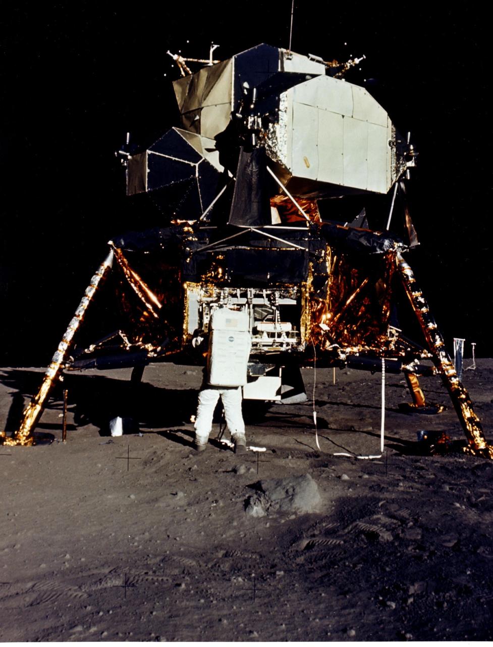 JOHNSON SPACE CENTER, HOUSTON, TEXAS  - Man's first landing on the Moon was accomplished at 4:17 p.m. today as Lunar Module "Eagle" touched down gently on the Sea of Tranquility on the east side of the Moon.  Astronaut Edwin E. Aldrin Jr., Lunar Module Pilot, removes scientific experiment packages from a stowage area in the Lunar Module's descent stage.  Left behind on the lunar surface by Aldrin and Neil A. Armstrong, Apollo 11 commander, were a Passive Seismic Experiments Package and a Laser-Ranging Retro-Reflector.