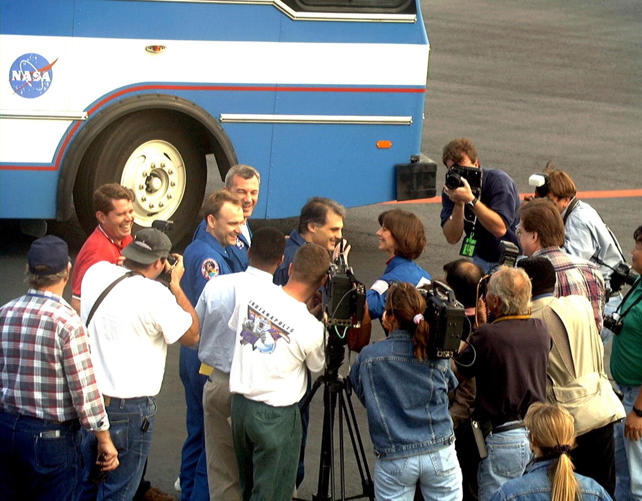 NASA astronaut and Mir 24 crew member David Wolf, M.D., enjoys a moment with the media at the Skid Strip at Cape Canaveral Air Station on Feb. 1 moments before his departure for Johnson Space Center. Other STS-89 crew members surrounding Dr. Wolf include, left to right, Pilot Joe Edwards Jr.; Commander Terrence Wilcutt; and Mission Specialist Bonnie Dunbar, Ph.D. In the red shirt behind Edwards is JSC Director of Flight Crew Operations David Leestma. The STS-89 crew that brought Dr. Wolf back to Earth arrived at KSC aboard the orbiter Endeavour Jan. 31, concluding the eighth Shuttle-Mir docking mission. STS-89 Mission Specialist Andrew Thomas, Ph.D., succeeded Dr. Wolf on Mir and is scheduled to remain on the Russian space station until the STS-91 Shuttle mission returns in June 1998. In addition to the docking and crew exchange, STS-89 included the transfer of science, logistical equipment and supplies between the two orbiting spacecrafts