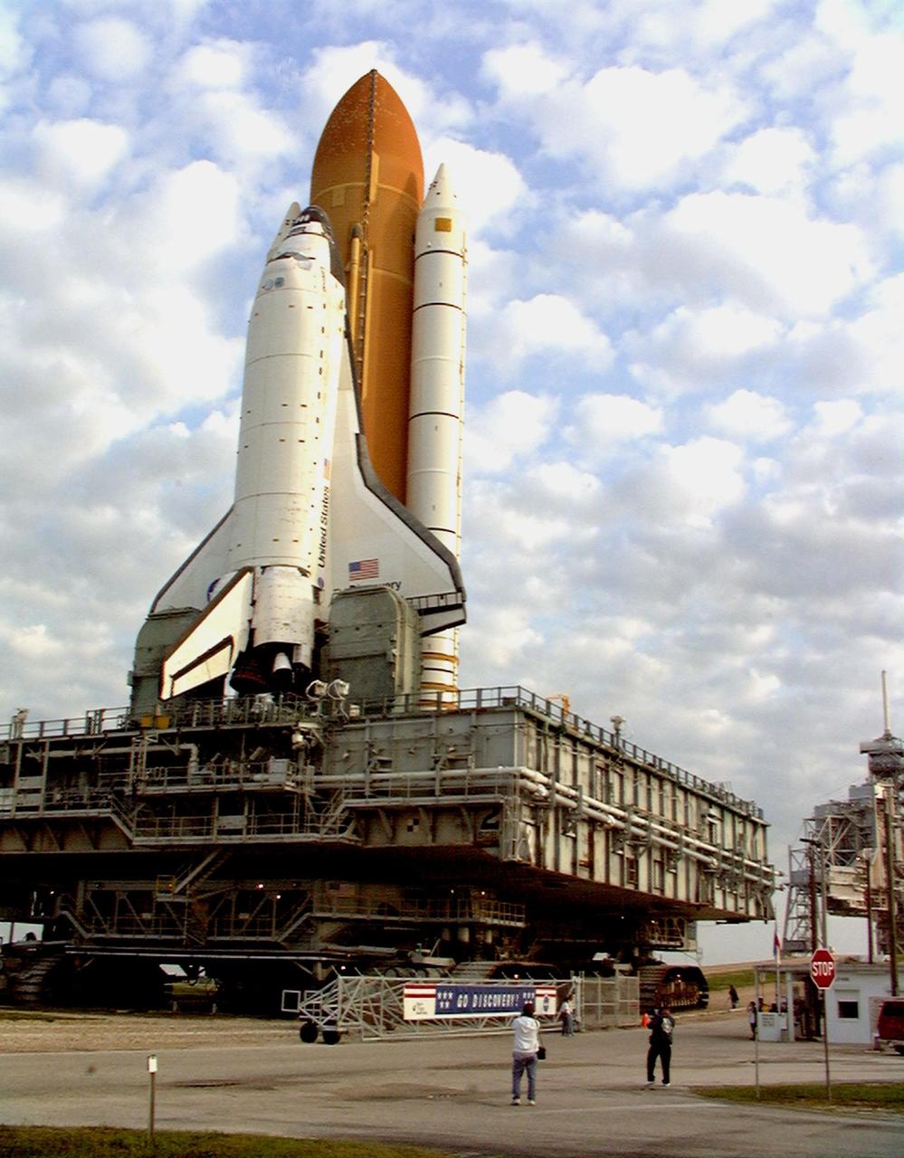 Against a popcorn-clouded blue sky, Space Shuttle Discovery, atop the mobile launcher platform and crawler transporter, ends its five-hour trek from the Vehicle Assembly Building as it crosses through the gate at Launch Pad 39B. Earlier in the week, the Shuttle was rolled back to the VAB from the pad to repair hail damage on the external tank's foam insulation. The 4.2-mile trek takes about five hours at the 1-mph speed of the crawler. Mission STS-96, the 94th launch in the Space Shuttle Program, is scheduled for liftoff May 27 at 6:48 a.m. EDT STS-96 is a logistics and resupply mission for the International Space Station, carrying such payloads as a Russian crane, the Strela; a U.S.-built crane; the Spacehab Oceaneering Space System Box (SHOSS), a logistics items carrier; and STARSHINE, a student-shared experiment