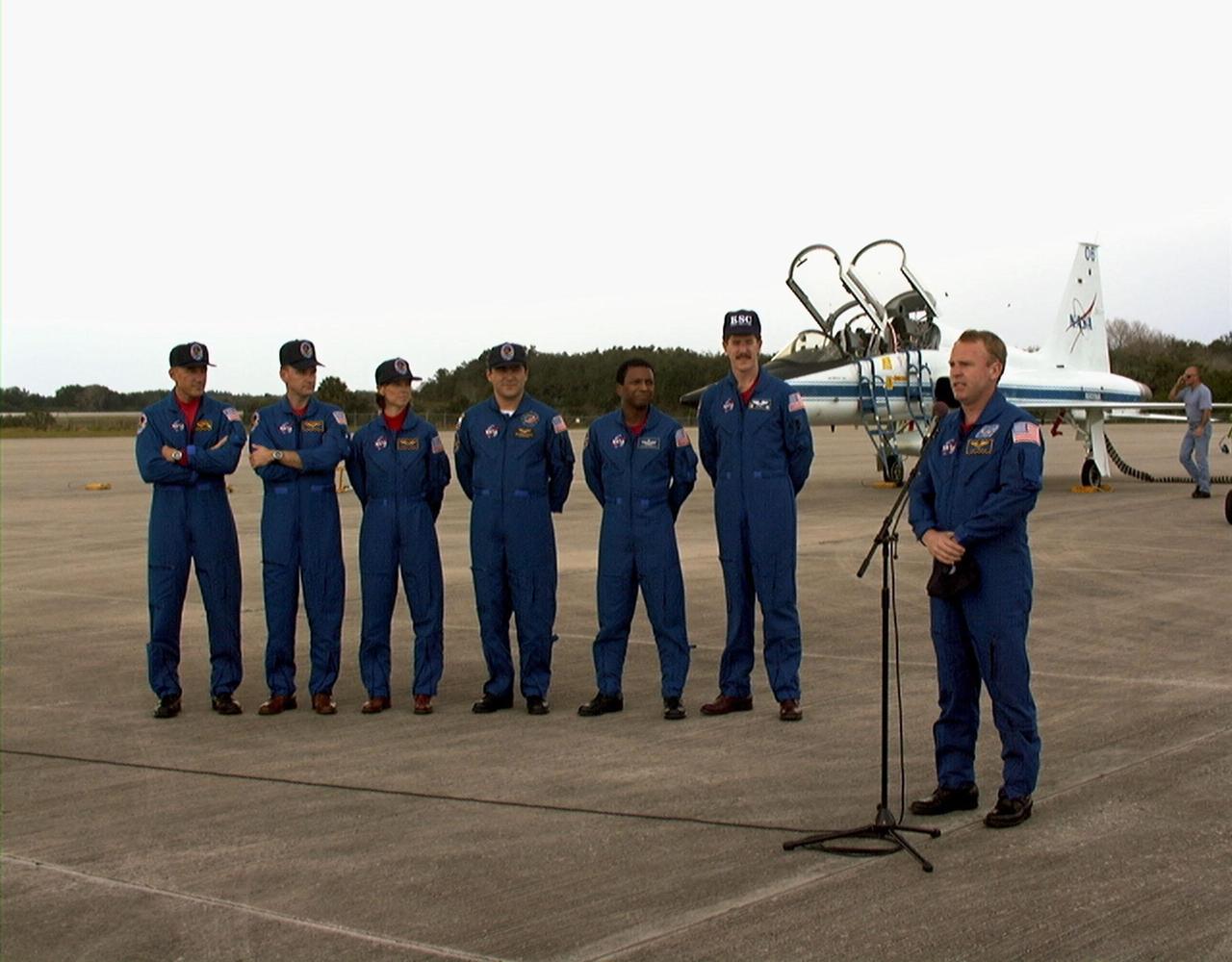 The STS-89 crew speak with the press after arriving at Kennedy Space Center's Shuttle Landing Facility in preparation for launch later this week. From left to right the crew include Commander Terrence Wilcutt; Pilot Joe Edwards Jr.; and Mission Specialists Bonnie Dunbar, Ph.D.; Salizhan Sharipov with the Russian Space Agency; Michael Anderson; James Reilly, Ph.D.; and Andrew Thomas, Ph.D. (at microphone). Dr. Thomas will succeed David Wolf, M.D., on the Russian Space Station Mir. Launch is scheduled for January 22 at 9:48 p.m. EST