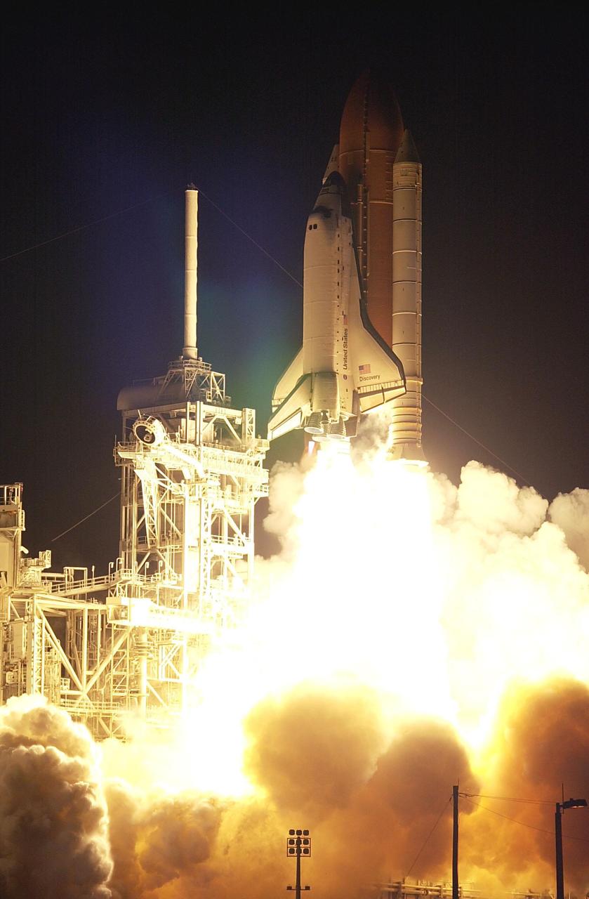 KENNEDY SPACE CENTER, FLA. -- Space Shuttle Discovery rises above the lighting mast on the Fixed Service Structure as it hurtles into the night sky on mission STS-92. Discovery launched on time at 7:17 p.m. EDT. Discovery carries a crew of seven on a construction flight to the International Space Station. Discovery also carries a payload that includes the Integrated Truss Structure Z-1, first of 10 trusses that will form the backbone of the Space Station, and the third Pressurized Mating Adapter that will provide a Shuttle docking port for solar array installation on the sixth Station flight and Lab installation on the seventh Station flight. Discovery’s landing is expected Oct. 22 at 2:10 p.m. EDT.; <i>[Photo taken with Nikon D1 camera.]</i