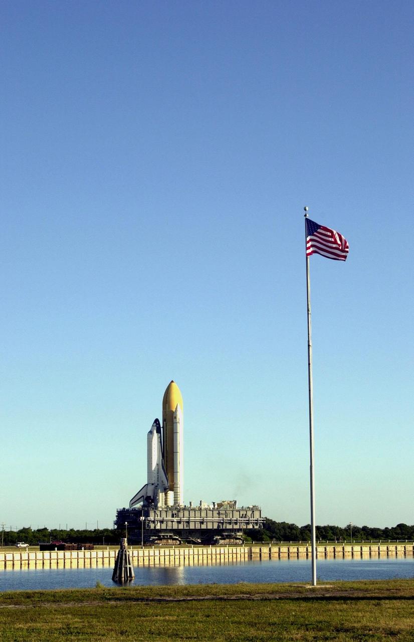 KENNEDY SPACE CENTER, Fla. -- Viewed across the turn basin from the Press mound, Space Shuttle Endeavour inches its way to Launch Pad 39B (on the horizon) via the crawlerway that leads from the Vehicle Assembly Building. The Shuttle is on the Mobile Launcher Platform (MLP) which is atop the crawler-transporter, moving on four double-tracked crawlers. The maximum speed of the loaded transporter is 1 mph. Endeavour is scheduled to be launched Nov. 30 at 10:01 p.m. EST on mission STS-97, the sixth construction flight to the International Space Station. Its payload includes the P6 Integrated Truss Structure and a photovoltaic (PV) module, with giant solar arrays that will provide power to the Station. The mission includes two spacewalks to complete the solar array connections
