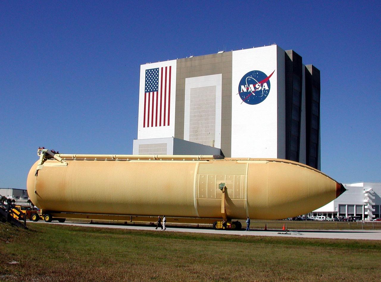 KENNEDY SPACE CENTER, FLA. -- A newly arrived external tank is transported from the turn basin to the Vehicle Assembly Building (VAB), seen behind the tank. External tanks are built by the NASA Michoud Assembly Facility in New Orleans and transported by barge to Cape Canaveral and then up the Banana River to the turn basin in the Launch Complex 39 Area. In the VAB, the tank will await stacking for a future Shuttle mission