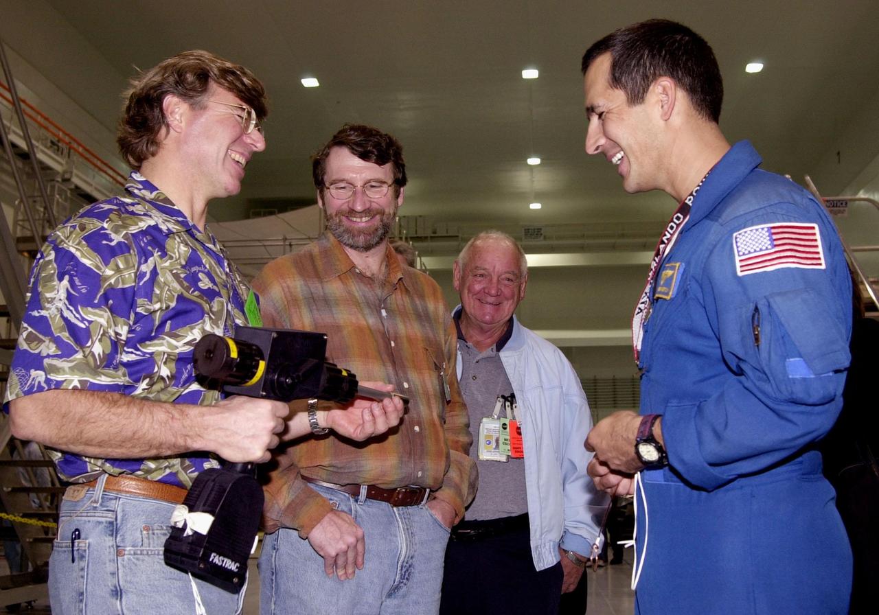 Astronaut John Herrington (right) shares a humorous moment with Steve Thomas (left) and Norm Abram (second from left), who are seen in the television series " This Old House." In the background is Johnny Johnson, media escort. Abram is at KSC to film an episode of "This Old House.