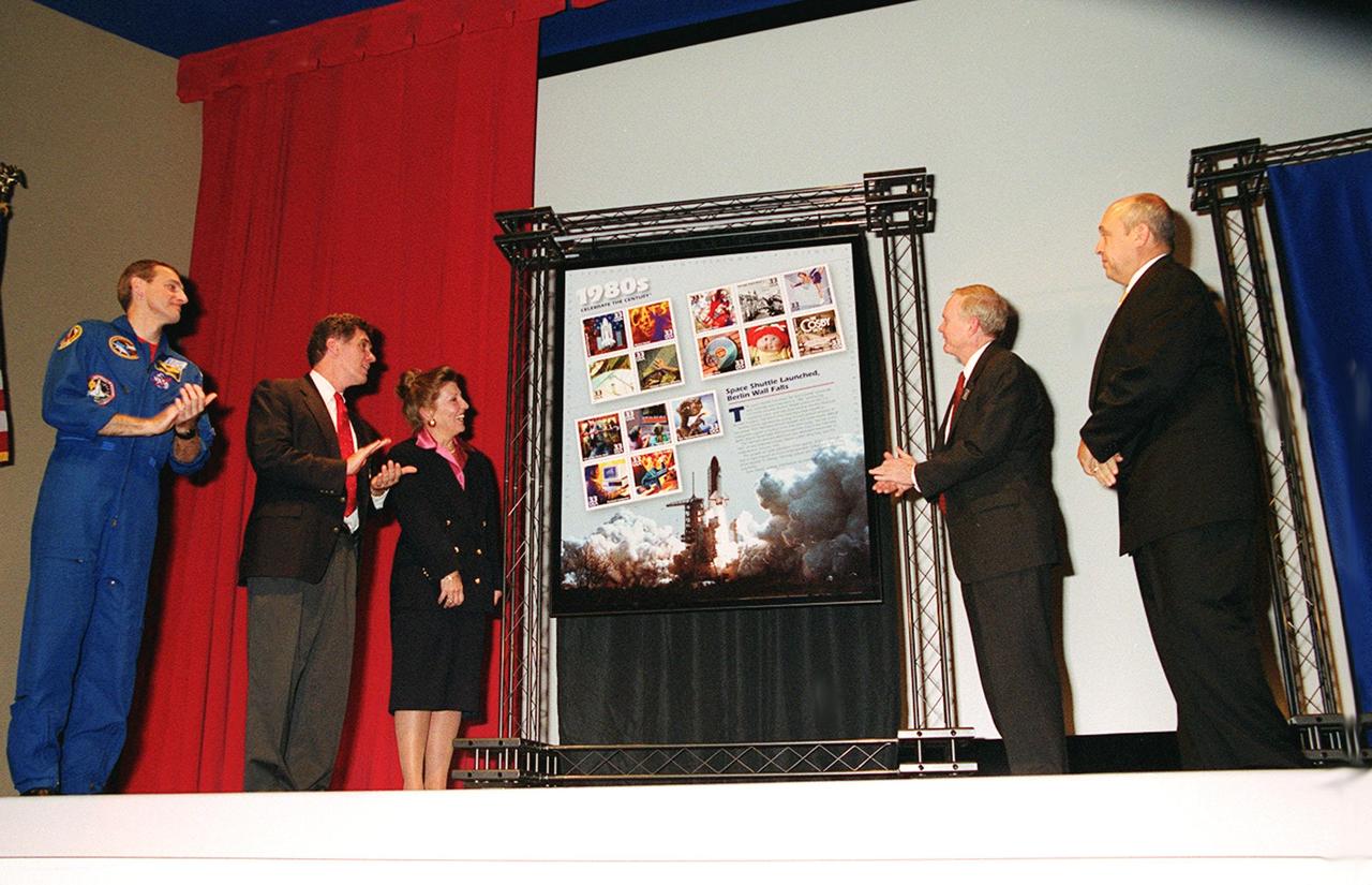 A new series of U.S. Postage stamps, The 1980s, is unveiled at the KSC Visitors Complex. Shown taking part in the &quot;First Day of Issue Ceremony&quot; are (left to right) astronaut Richard Linnehan, U.S. Representative, 15th Congressional District, Dave Weldon, U.S. Postal Service District Manager Viki Brennan, Center Director Roy Bridges and President of the Visitor Complex Rick Abramson. Among the stamps issued is one of Space Shuttle Columbia, first launched in April 1981. This collection of stamps is the ninth in the Post Office's &quot;Celebrate the Century&quot; commemorative series honoring the last 100 years of American history