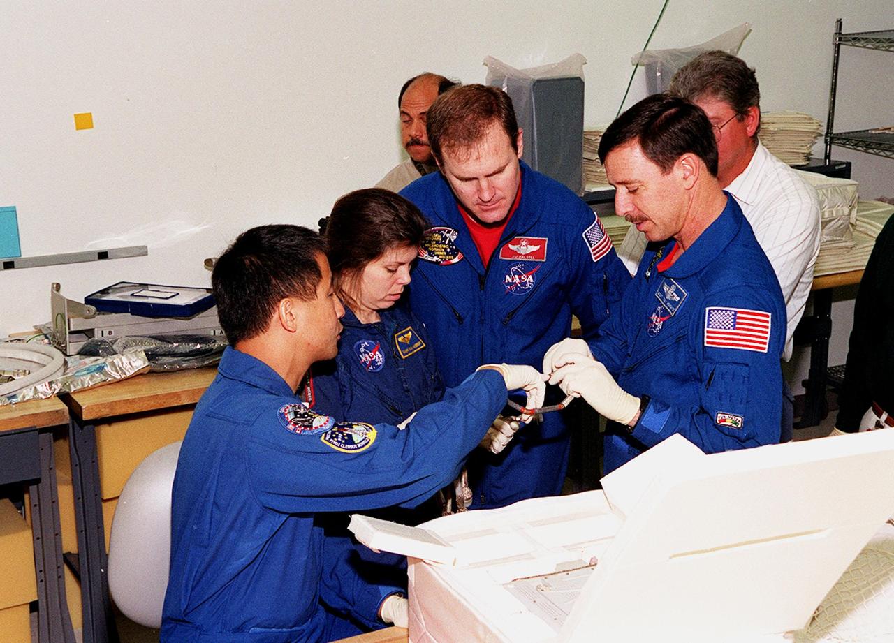 KENNEDY SPACE CENTER, FLA. -- At SPACEHAB, in Cape Canaveral, the STS-101 crew inspect equipment and payload for their mission. From left to right are Mission Specialist Edward Tsang Lu, Mary Ellen Weber (Ph.D.), Commander James D. Halsell Jr. and Pilot Scott J. "Doc" Horowitz (Ph.D). are taking part in a Crew Equipment Interface Test, which gives them an opportunity to look over equipment and payloads that will fly on the mission. Space Shuttle Atlantis will be carrying the SPACEHAB Double Module, which carries internal logistics and resupply cargo for station outfitting. Launch of Atlantis on mission STS-101 is scheduled no earlier than April 13, 2000