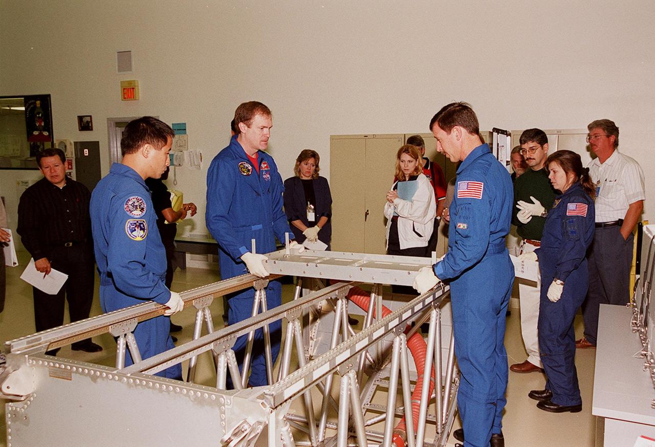 KENNEDY SPACE CENTER, FLA. -- At SPACEHAB, in Cape Canaveral, members of the STS-101 crew inspect equipment and payload for their mission. From left to right (in uniform) are Mission Specialist Edward Tsang Lu, Commander James D. Halsell Jr., Pilot Scott J. "Doc" Horowitz (Ph.D) and Mission Specialist Mary Ellen Weber (Ph.D.). They are taking part in a Crew Equipment Interface Test, which gives them an opportunity to look over equipment and payloads that will fly on the mission. Space Shuttle Atlantis will be carrying the SPACEHAB Double Module, which carries internal logistics and resupply cargo for station outfitting. Launch of Atlantis on mission STS-101 is scheduled no earlier than April 13, 2000