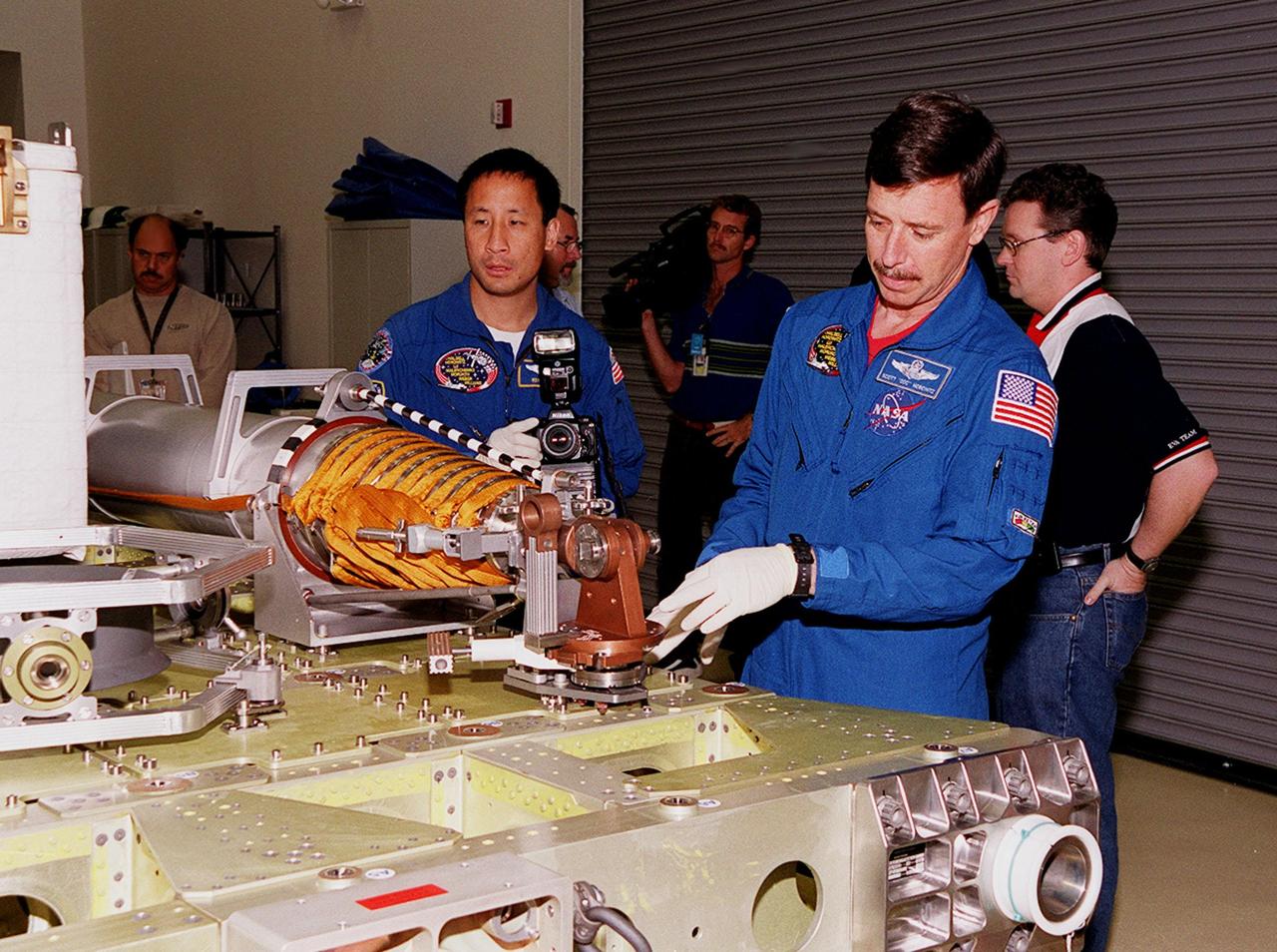 KENNEDY SPACE CENTER, FLA. -- At SPACEHAB, in Cape Canaveral, looking over the Russian crane, Strela, are STS-101 Mission Specialist Edward Tsang Lu (left) and Pilot Scott J. "Doc" Horowitz (Ph.D). Lu, Horowitz and other members of the crew are taking part in a Crew Equipment Interface Test, which gives them an opportunity to look over equipment and payloads that will fly on the mission. Space Shuttle Atlantis will be carrying the SPACEHAB Double Module, which carries internal logistics and resupply cargo for station outfitting. Launch of Atlantis on mission STS-101 is scheduled no earlier than April 13, 2000