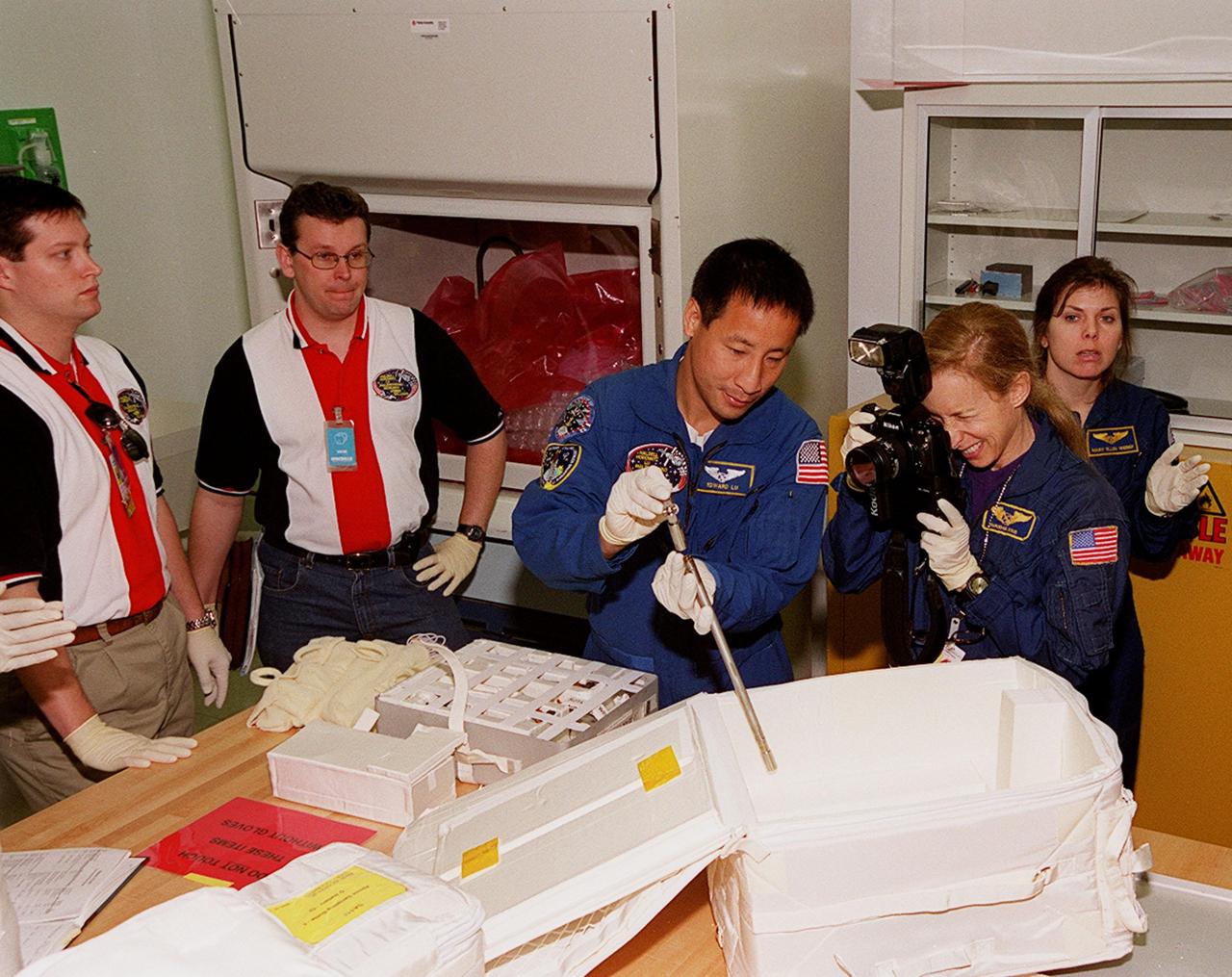 KENNEDY SPACE CENTER, FLA. -- At SPACEHAB, in Cape Canaveral, members of the STS-101 crew are taking part in a Crew Equipment Interface Test, which gives them an opportunity to look over equipment and payloads that will fly on the mission. At center is Mission Specialist Edward Tsang Lu; at right is Mission Specialist Mary Ellen Weber (Ph.D.). Between the, holding the camera, is astronaut Marsha Ivins, who is assigned to mission STS-98. On mission STS-101, Space Shuttle Atlantis will be carrying the SPACEHAB Double Module, which carries internal logistics and resupply cargo for station outfitting. Launch of Atlantis is scheduled no earlier than April 13, 2000