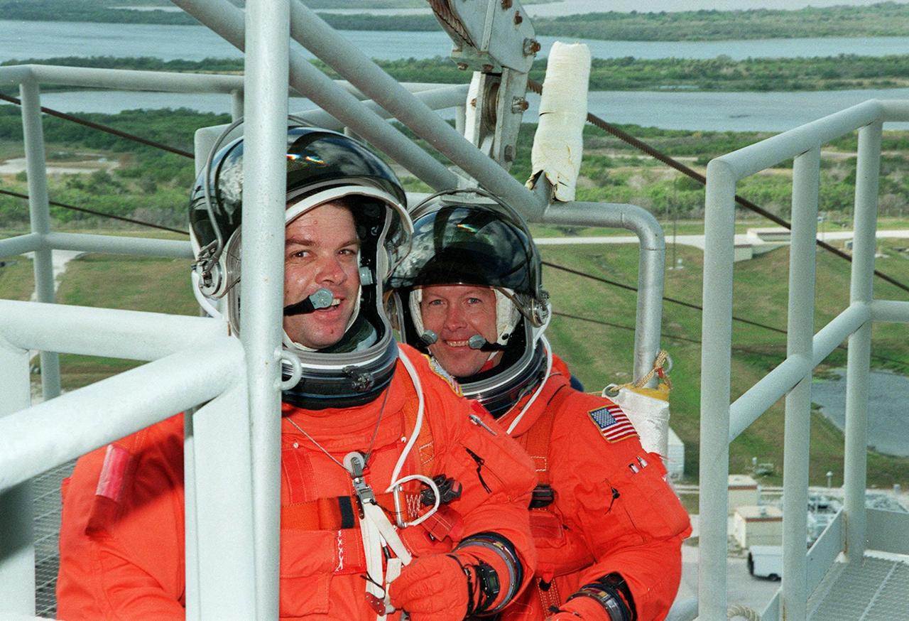 KENNEDY SPACE CENTER, Fla. -- At Launch Pad 39A, STS-99 Mission Specialists Gerhard Thiele (Ph.D.), of the European Space Agency (in front), and Janet Kavandi (Ph.D.) prepare to practice emergency egress procedures with a slidewire basket. Seven slidewires, with flatbottom baskets suspended from each wire, extend from the Fixed Service Structure at the orbiter access arm level. These baskets could provide an escape route for the astronauts until the final 30 seconds of the countdown in case of an emergency. The crew is taking part in Terminal Countdown Demonstration Test (TCDT) activities that provide the crew with simulated countdown exercises, emergency egress training, and opportunities to inspect the mission payloads in the orbiter's payload bay. STS-99 is the Shuttle Radar Topography Mission, which will chart a new course, using two antennae and a 200-foot-long section of space station-derived mast protruding from the payload bay to produce unrivaled 3-D images of the Earth's surface. The result of the Shuttle Radar Topography Mission could be close to 1 trillion measurements of the Earth's topography. Besides contributing to the production of better maps, these measurements could lead to improved water drainage modeling, more realistic flight simulators, better locations for cell phone towers, and enhanced navigation safety. Launch of Endeavour on the 11-day mission is scheduled for Jan. 31 at 12:47 p.m. EST.