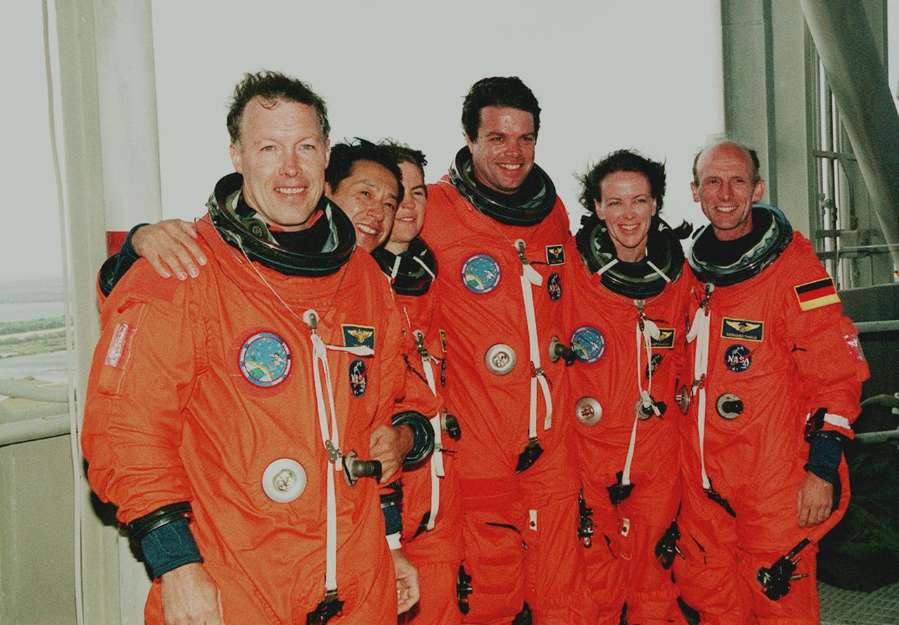 KENNEDY SPACE CENTER, Fla. --  At the 195-foot level of the Fixed Service Structure on Launch Pad 39A, the STS-99 crew pose for a photograph during Terminal Countdown Demonstration Test (TCDT) activities. Standing left to right are Pilot Dominic Gorie, Mission Specialist Mamoru Mohri (Ph.D.), Mission Specialist Janice Voss (Ph.D.), Commander Kevin Kregel, Mission Specialist Janet Lynn Kavandi (Ph.D.), and Mission Specialist Gerhard Thiele (Ph.D.). Thiele is with the European Space Agency and Mohri is with the National Space Development Agency (NASDA) of Japan. The TCDT provides the crew with simulated countdown exercises, emergency egress training, and opportunities to inspect the mission payloads in the orbiter's payload bay. STS-99 is the Shuttle Radar Topography Mission, which will chart a new course, using two antennae and a 200-foot-long section of space station-derived mast protruding from the payload bay to produce unrivaled 3-D images of the Earth's surface. The result of the Shuttle Radar Topography Mission could be close to 1 trillion measurements of the Earth's topography. Besides contributing to the production of better maps, these measurements could lead to improved water drainage modeling, more realistic flight simulators, better locations for cell phone towers, and enhanced navigation safety. Launch of Endeavour on the 11-day mission is scheduled for Jan. 31 at 12:47 p.m. EST