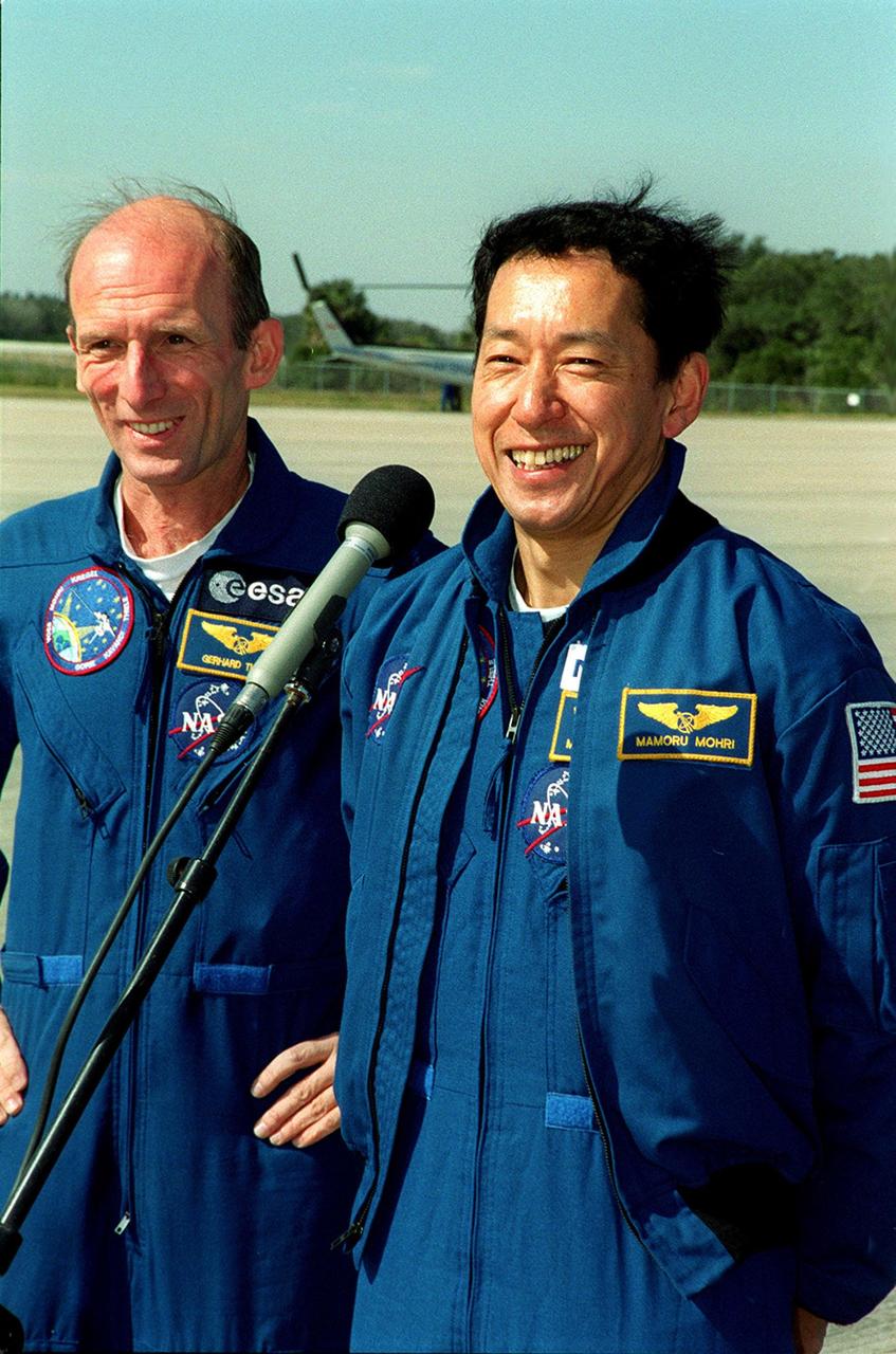 After the crew arrival at KSC's Shuttle Landing Facility, STS-99 Mission Specialist Mamoru Mohri (Ph.D.), at right, talks to the media. At left is Mission Specialist Gerhard Thiele (Ph.D.). Thiele is with the European Space Agency and Mohri is with the National Space Development Agency (NASDA) of Japan. Over the next few days, the crew will review mission procedures, conduct test flights in the Shuttle Training Aircraft and undergo routine preflight medical exams. STS-99 is the Shuttle Radar Topography Mission, which will chart a new course, using two antennae and a 200-foot-long section of space station-derived mast protruding from the payload bay to produce unrivaled 3-D images of the Earth's surface. The result of the Shuttle Radar Topography Mission could be close to 1 trillion measurements of the Earth's topography. Besides contributing to the production of better maps, these measurements could lead to improved water drainage modeling, more realistic flight simulators, better locations for cell phone towers, and enhanced navigation safety. Launch of Endeavour is scheduled for Jan. 31 at 12:47 p.m. EST