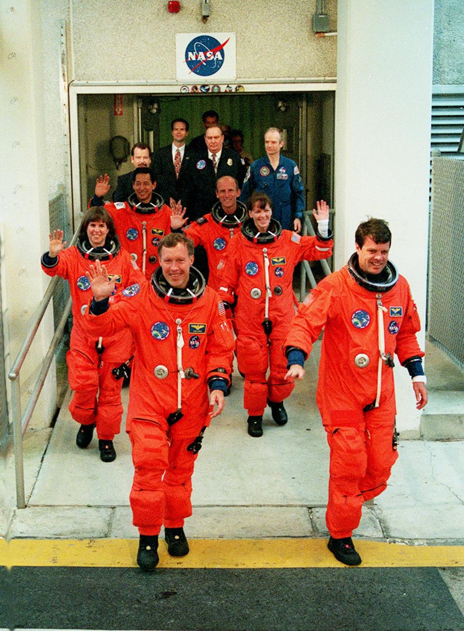 The STS-99 crew wave to onlookers as they leave the Operations and Checkout Building enroute to Launch Pad 39A and liftoff of Space Shuttle Endeavour, targeted for 12:47 p.m. EST. In their orange launch and entry suits, they are (foreground) Pilot Dominic Gorie and Commander Kevin Kregel. Behind them (left to right) are Mission Specialists Janice Voss (Ph.D.), Mamoru Mohri (Ph.D.), Gerhard Thiele and Janet Lynn Kavandi (Ph.D.). Mohri is with the National Space Development Agency (NASDA) of Japan, and Thiele is with the European Space Agency. The SRTM will chart a new course to produce unrivaled 3-D images of the Earth's surface, using two antennae and a 200-foot-long section of space station-derived mast protruding from the payload bay. The result of the Shuttle Radar Topography Mission could be close to 1 trillion measurements of the Earth's topography. Besides contributing to the production of better maps, these measurements could lead to improved water drainage modeling, more realistic flight simulators, better locations for cell phone towers, and enhanced navigation safety. The mission is expected to last about 11days, with Endeavour landing at KSC Friday, Feb. 11, at 4:55 p.m. EST