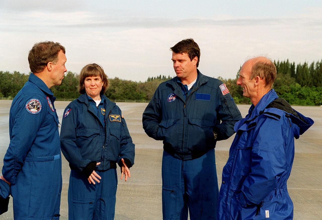 On the runway at the Shuttle Landing Facility, STS-99 crew members Pilot Dominic Gorie, Mission Specialist Janice Voss, Commander Kevin Kregel and Mission Specialist Gerhard Thiele discuss departure plans to Houston. Kregel and Gorie will be piloting T-38 jets with Voss and Thiele as passengers. During the Jan. 31 launch countdown, Endeavour's enhanced master events controller (E-MEC) No. 2 failed a standard preflight test. Launch was postponed and Shuttle managers decided to replace the E-MEC located in the orbiter's aft compartment. Launch controllers will be in a position to begin the STS-99 countdown the morning of Feb. 6 and ready to support a launch midto latenext week pending availability of the Eastern Range. The postponed launch gives the crew an opportunity for more training and time with their families. Known as the Shuttle Radar Topography Mission, it will chart a new course to produce unrivaled 3-D images of the Earth's surface, using two antennae and a 200-foot-long section of space station-derived mast protruding from the payload bay. The result could be close to 1 trillion measurements of the Earth's topography. Besides contributing to the production of better maps, these measurements could lead to improved water drainage modeling, more realistic flight simulators, better locations for cell phone towers, and enhanced navigation safety
