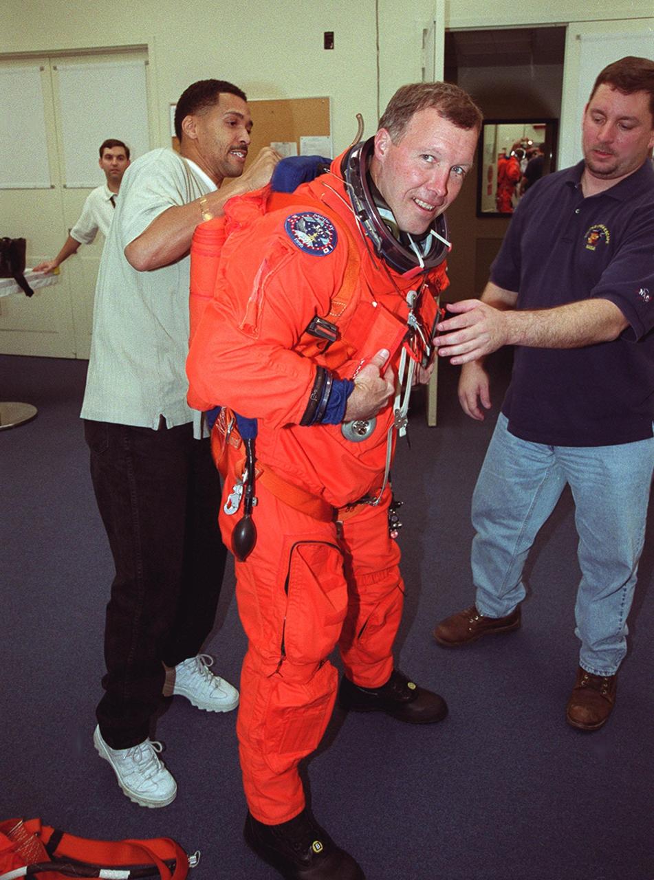 In the Operations and Checkout Building's suitup room, Carlos Gillis (left) and Leonard Groce (right)help STS-99 Pilot Dominic Gorie with his suit check. Gillis and Groce are with United Space Alliance. Gorie and other crew members Commander Kevin Kregel, and Mission Specialists Janet Kavandi, Janice Voss, Gerhard Thiele of Germany and Mamoru Mohri of Japan are preparing for launch of their mission on Feb. 11 at 12:30 p.m. EST aboard Space Shuttle Endeavour. STS-99 is the Shuttle Radar Topography Mission, which will produce unrivaled 3-D images of the Earth's surface. The result of the Shuttle Radar Topography Mission could be close to 1 trillion measurements of the Earth's topography. Landing is expected at KSC on Feb. 22 at 4:36 p.m. EST