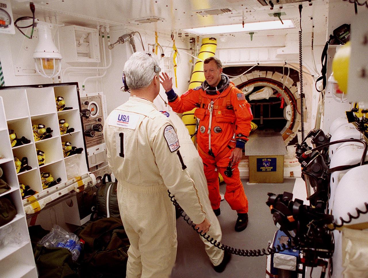 STS-99 Pilot Dominic Gorie appears to wave while the closeout crew in the White Room checks his launch and entry suit before he enters orbiter Endeavour. In the foreground is Chris Meinert, closeout chief. The White Room is an environmental chamber at the end of the orbiter access arm, on the fixed service structure, that provides entry to the orbiter crew compartment. STS-99, known as the Shuttle Radar Topography Mission (SRTM), will chart a new course to produce unrivaled 3-D images of the Earth's surface. The result of the Shuttle Radar Topography Mission could be close to 1 trillion measurements of the Earth's topography. Scheduled for liftoff at 12:30 p.m. EST, the mission is expected to last 11days, with Endeavour landing at KSC Tuesday, Feb. 22, at 4:36 p.m. EST. This is the 97th Shuttle flight and 14th for Shuttle Endeavour
