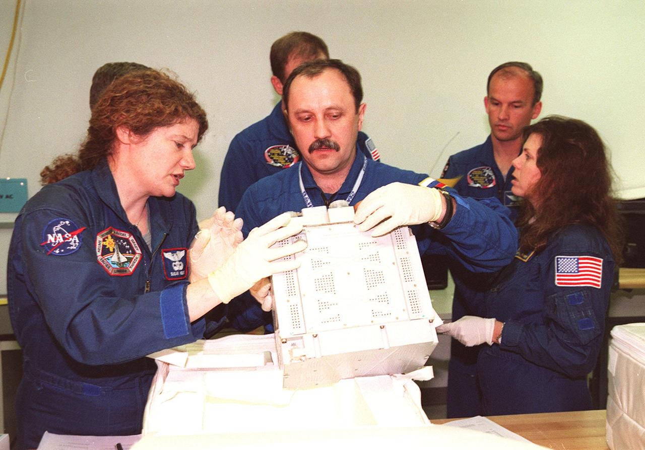 KENNEDY SPACE CENTER, FLA. -- At SPACEHAB, in Cape Canaveral, Fla., members of the STS-101 crew take part in Crew Equipment Interface Test (CEIT) activities, learning about some of the equipment they will be working with on their mission to the International Space Station. Looking over one of the elements are Mission Specialists Susan Helms and Yuri Usachev. Behind them are Mission Specialist James Voss, Commander James Halsell, and Mission Specialists Jeffrey Williams and Mary Ellen Weber. Also taking part in the CEIT is Pilot Scott Horowitz (not shown). The STS-101 crew will be responsible for preparing the Space Station for the arrival of the Zvezda Service Module, expected to be launched by Russia in July 2000. Also, the crew will conduct one space walk to perform maintenance on the Space Station and deliver logistics and supplies. This will be the third assembly flight for the Space Station. STS-101 is scheduled to launch no earlier than April 13 from Launch Pad 39A