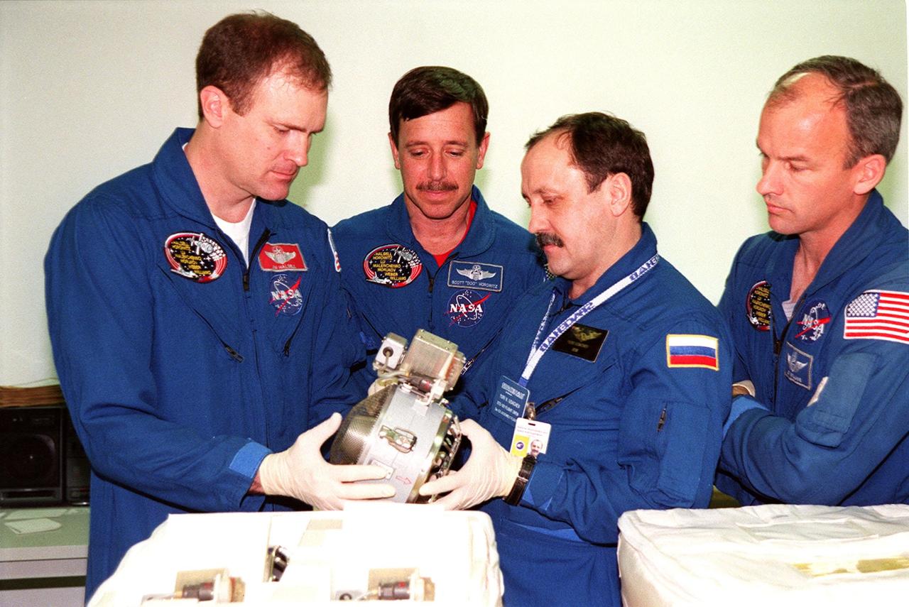 KENNEDY SPACE CENTER, FLA. -- Members of the STS-101 crew take part in Crew Equipment Interface Test (CEIT) activities at SPACEHAB, in Cape Canaveral, Fla., where they are learning about some of the equipment they will be working with on their mission to the International Space Station. Commander James Halsell, Pilot Scott Horowitz, and Mission Specialists Yuri Usachev and Jeffrey Williams look over one of the components. Other crew members taking part in the CEIT are Mission Specialists Mary Ellen Weber, James Voss and Susan Helms. The STS-101 crew will be responsible for preparing the Space Station for the arrival of the Zvezda Service Module, expected to be launched by Russia in July 2000. Also, the crew will conduct one space walk to perform maintenance on the Space Station and deliver logistics and supplies. This will be the third assembly flight for the Space Station. STS-101 is scheduled to launch no earlier than April 13 from Launch Pad 39A
