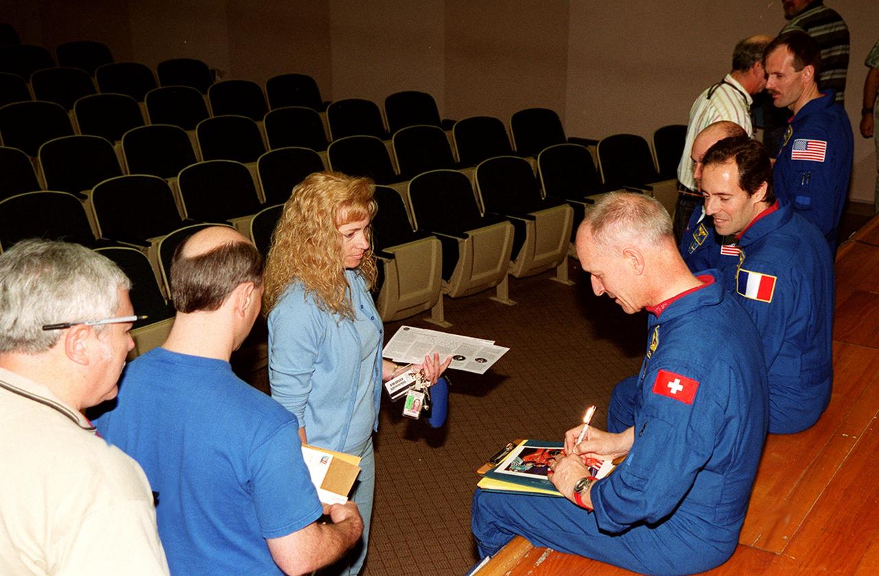 KENNEDY SPACE CENTER, FLA. -- After a presentation at KSC for employees and VIPs about their mission, STS-103 crew members sign autographs. From left are Mission Specialists Claude Nicollier and Jean-Francois Clervoy, Pilot Scott Kelly and Mission Specialist Steven Smith. The STS-103 mission, servicing the Hubble Space Telescope, included three spacewalks. STS-103 launched Dec. 19, 1999, and landed Dec. 27, 1999.