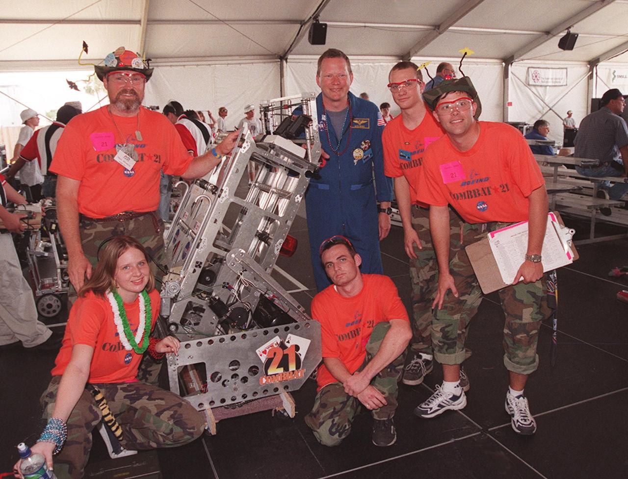 Astronaut David Brown poses with members of the team known as ComBBat, representing Central Florida's Astronaut and Titusville high schools. ComBBat was teamed with Boeing at KSC and Brevard Community College. Students from all over the country are at the KSC Visitor Complex for the FIRST (For Inspiration and Recognition of Science and Technology) Southeast Regional competition being held March 9-11 in the Rocket Garden. Teams of high school students are testing the limits of their imagination using robots they have designed, with the support of business and engineering professionals and corporate sponsors, to compete in a technological battle against other schools' robots. Of the 30 high school teams competing, 16 are Florida teams co-sponsored by NASA and KSC contractors. Local high schools participating are Astronaut, Bayside, Cocoa Beach, Eau Gallie, Melbourne, Melbourne Central Catholic, Palm Bay, Rockledge, Satellite, and Titusville