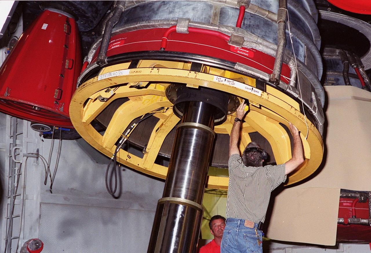 KENNEDY SPACE CENTER, FLA. -- A worker in the Vehicle Assembly Building adjusts the equipment being used for the removal of Main Engine No. 1 on Space Shuttle Atlantis. An inventory review concerning defective main engine fuel pump tip seals indicated that defective seals may be present on the fuel pump for the engine. The decision was made to replace the suspect engine with one originally slated for Discovery. The main engine nozzle, visible in the photo, is 7.8 feet across and 9.4 feet high. Space Shuttle Atlantis is scheduled to launch no earlier than April 17, 2000, on mission STS-101 to resupply the International Space Station for the arrival of the next pressurized module, the Russian-built Zvezda
