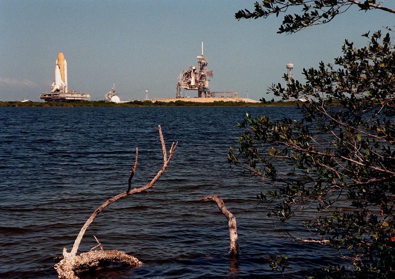 Seen from across the backwaters of the Indian River Lagoon, the Space Shuttle Atlantis, atop the mobile launcher platform and crawler-transporter, nears Launch Pad 39A at 1 mph. The crawler-transporter takes about five hours to cover the 3.4 miles from the Vehicle Assembly Building to the launch pad. The crawler-transporter carries its cargo at 1 mph, taking about five hours to cover the 3.4 miles from the Vehicle Assembly Building to the launch pad. A leveling system on the crawler-transporter keeps the top of the Space Shuttle vertical, especially negotiating the ramp leading to the launch pads and when it is raised and lowered on pedestals at the pad. Liftoff of Atlantis on mission STS-101 is scheduled for April 17 at 7:03 p.m. EDT. STS-101 is a logistics and resupply mission for the International Space Station, to restore full redundancy to the International Space Station power system in preparation for the arrival of the next pressurized module, the Russian-built Zvezda