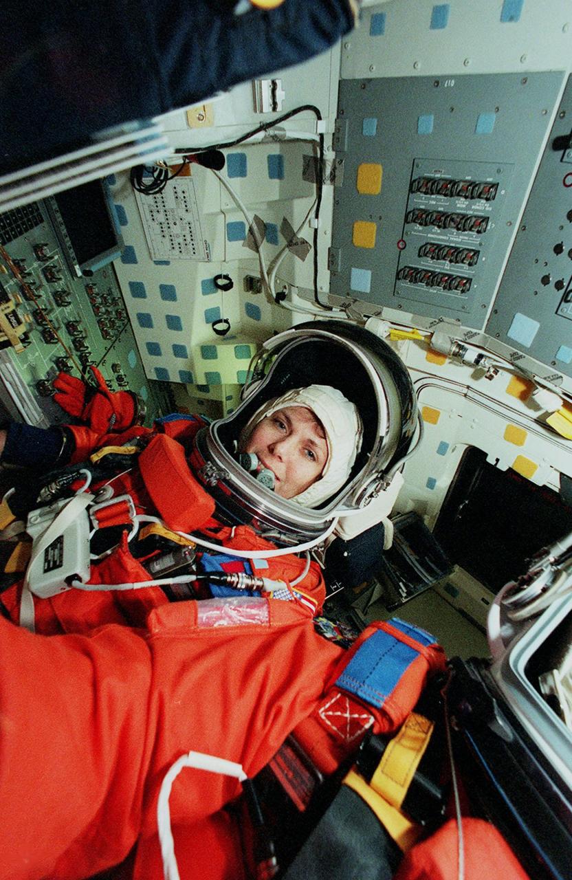 KENNEDY SPACE CENTER, FLA. -- STS-101 Mission Specialist Mary Ellen Weber takes her seat inside Space Shuttle Atlantis before taking part in a simulated launch countdown. The countdown is part of Terminal Countdown Demonstration Test (TCDT) activities that also include emergency egress training and familiarization with the payload. Other crew members taking part are Commander James D. Halsell Jr., Pilot Scott J. "Doc" Horowitz and Mission Specialists Mary Ellen Weber, James Voss, Jeffrey N. Williams, Susan Helms, and Yury Usachev of Russia. During their mission to the International Space Station, the STS-101 crew will be delivering logistics and supplies, plus preparing the Station for the arrival of the Zvezda Service Module, expected to be launched by Russia in July 2000. Also, the crew will conduct one space walk to perform maintenance on the Space Station. This will be the third assembly flight for the Space Station. STS-101 is scheduled to launch April 24 at 4:15 p.m. from Launch Pad 39A