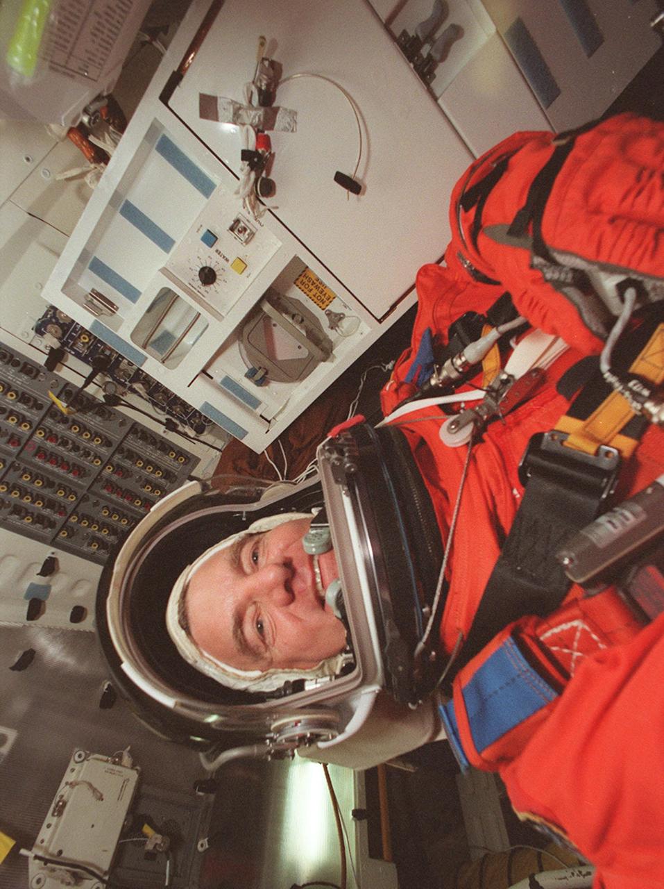 KENNEDY SPACE CENTER, FLA. -- STS-101 Mission Specialist James Voss takes his seat inside Space Shuttle Atlantis for a simulated launch countdown. The countdown is part of Terminal Countdown Demonstration Test (TCDT) activities that also include emergency egress training and familiarization with the payload. Other crew members taking part are Commander James D. Halsell Jr., Pilot Scott J. "Doc" Horowitz and Mission Specialists Mary Ellen Weber, Jeffrey N. Williams, Susan J. Helms, and Yury Usachev of Russia. During their mission to the International Space Station, the STS-101 crew will be delivering logistics and supplies, plus preparing the Station for the arrival of the Zvezda Service Module, expected to be launched by Russia in July 2000. Also, the crew will conduct one space walk to perform maintenance on the Space Station. This will be the third assembly flight for the Space Station. STS-101 is scheduled to launch April 24 at 4:15 p.m. from Launch Pad 39A