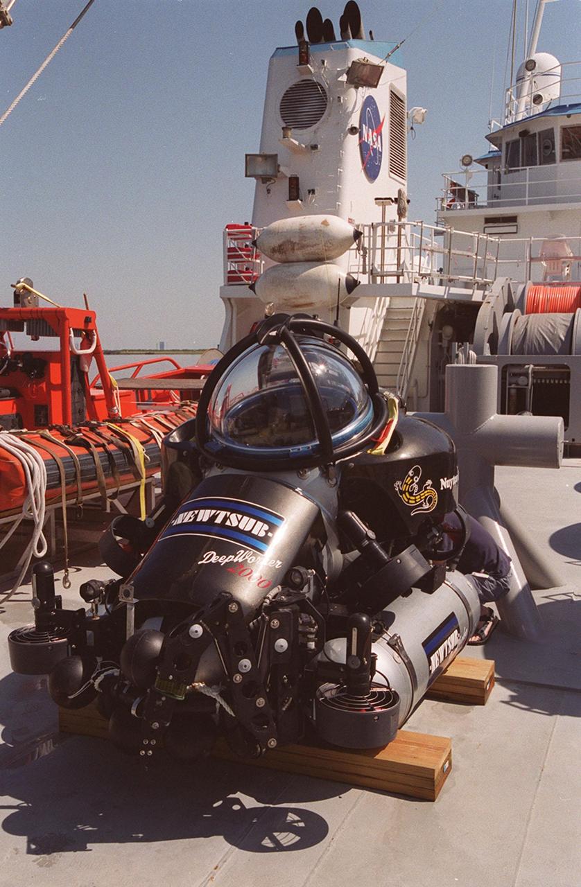 The one-man submarine dubbed DeepWorker 2000 sits on the deck of Liberty Star, one of two KSC solid rocket booster recovery ships. The sub is being tested on its ability to duplicate the sometimes hazardous job United Space Alliance (USA) divers perform to recover the expended boosters in the ocean after a launch. The boosters splash down in an impact area about 140 miles east of Jacksonville and after recovery are towed back to KSC for refurbishment by the specially rigged recovery ships. DeepWorker 2000 was built by Nuytco Research Ltd., North Vancouver, British Columbia. It is 8.25 feet long, 5.75 feet high, and weighs 3,800 pounds. USA is a prime contractor to NASA for the Space Shuttle program