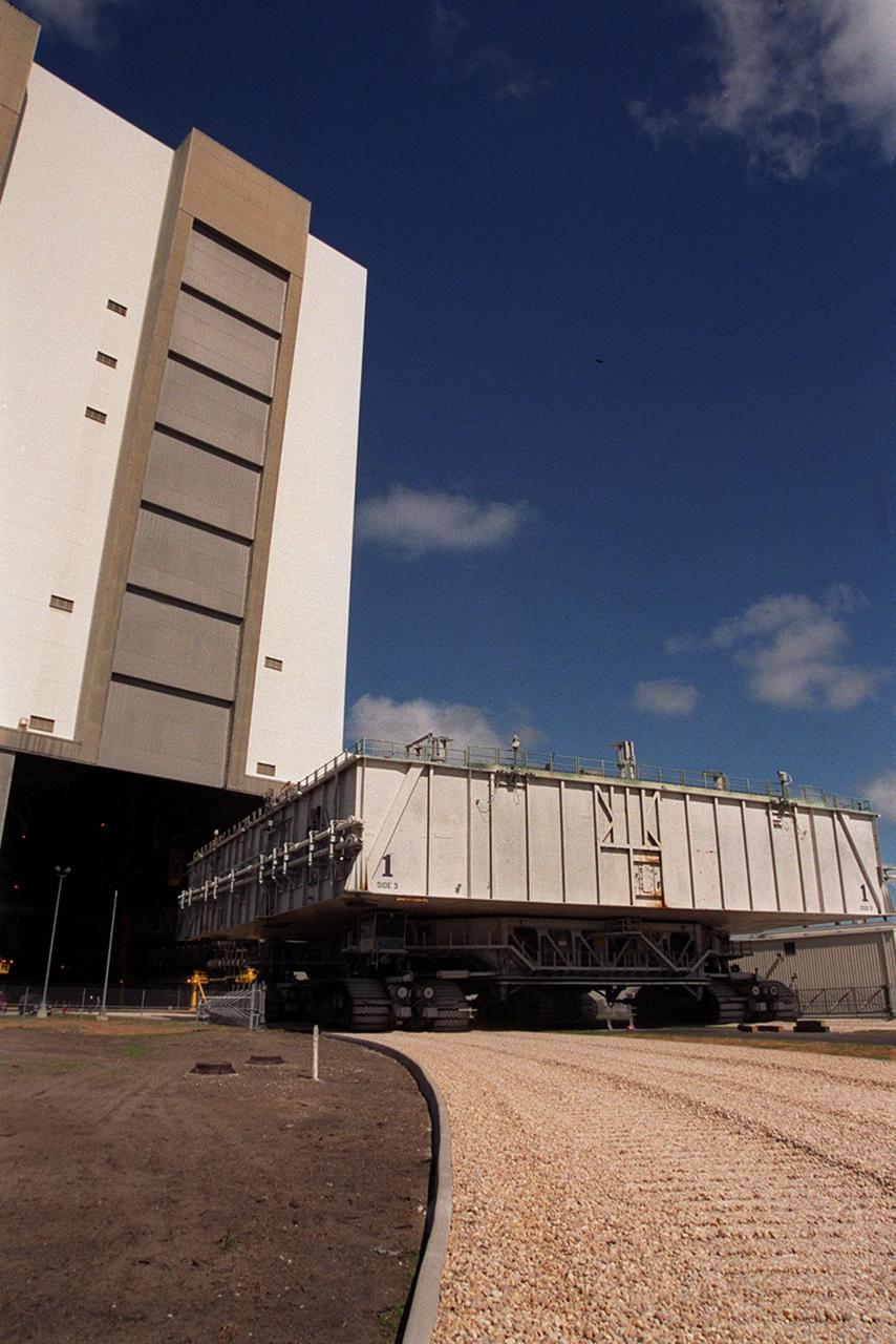 KENNEDY SPACE CENTER, FLA. -- A mobile launcher platform atop a crawler-transporter, heads to the open door of the Vehicle Assembly Building high bay 2. As part of the Safe Haven project, a once-buried portion of the crawlerway was restored to enable rollout of a Shuttle from this third stacking area. The primary goal of the Safe Haven construction project was to strengthen readiness for hurricane season by expanding the VAB’s storage capacity. The new area, in high bay 2, will allow NASA to preassemble stacks and still have room in the VAB to pull a Shuttle back from the pad if severe weather threatens. Potential rollouts of the Space Shuttle to the launch pad from high bay 2 will involve making a turn around the north side of the VAB in contrast to the straight rollouts from high bays 1 and 3, on the east side of the VAB facing the launch pads