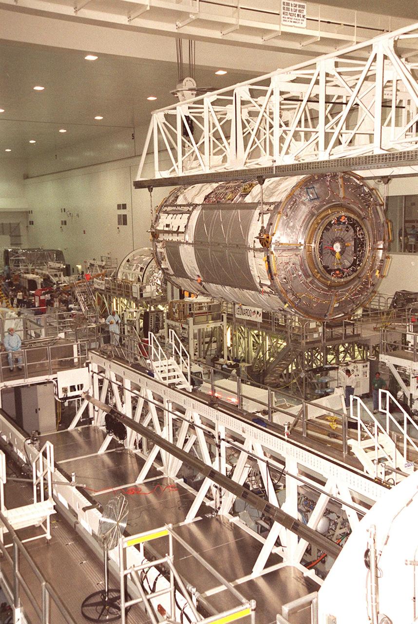 KENNEDY SPACE CENTER, FLA. -- Suspended under an overhead crane, the U.S. Lab Destiny nears the weigh stand at left. A component of the International Space Station, Destiny is scheduled to fly on mission STS-98 in early 2001. During the mission, the crew will install the Lab during a series of three space walks. The STS-98 mission will provide the station with science research facilities and expand its power, life support and control capabilities. The U.S. Lab module continues a long tradition of microgravity materials research, first conducted by Skylab and later Shuttle and Spacelab missions. Destiny is expected to be a major feature in future research, providing facilities for biotechnology, fluid physics, combustion, and life sciences research