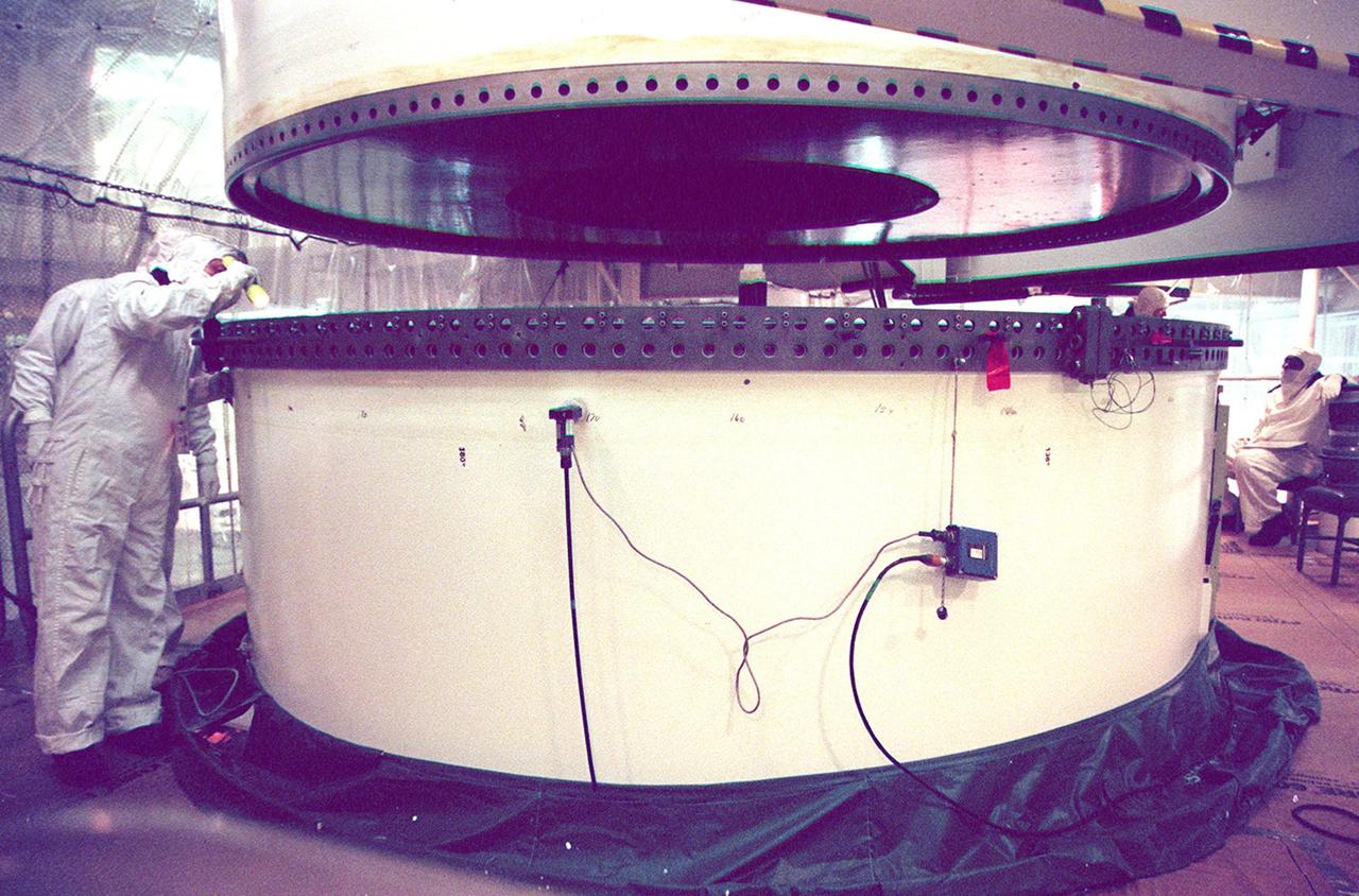 In the Vehicle Assembly Building, workers check the lower segment of a solid rocket booster (SRB) before mating it to the one above. The SRB is part of the stack for the STS-92 mission, scheduled for launch Oct. 5 from Launch Pad 39A