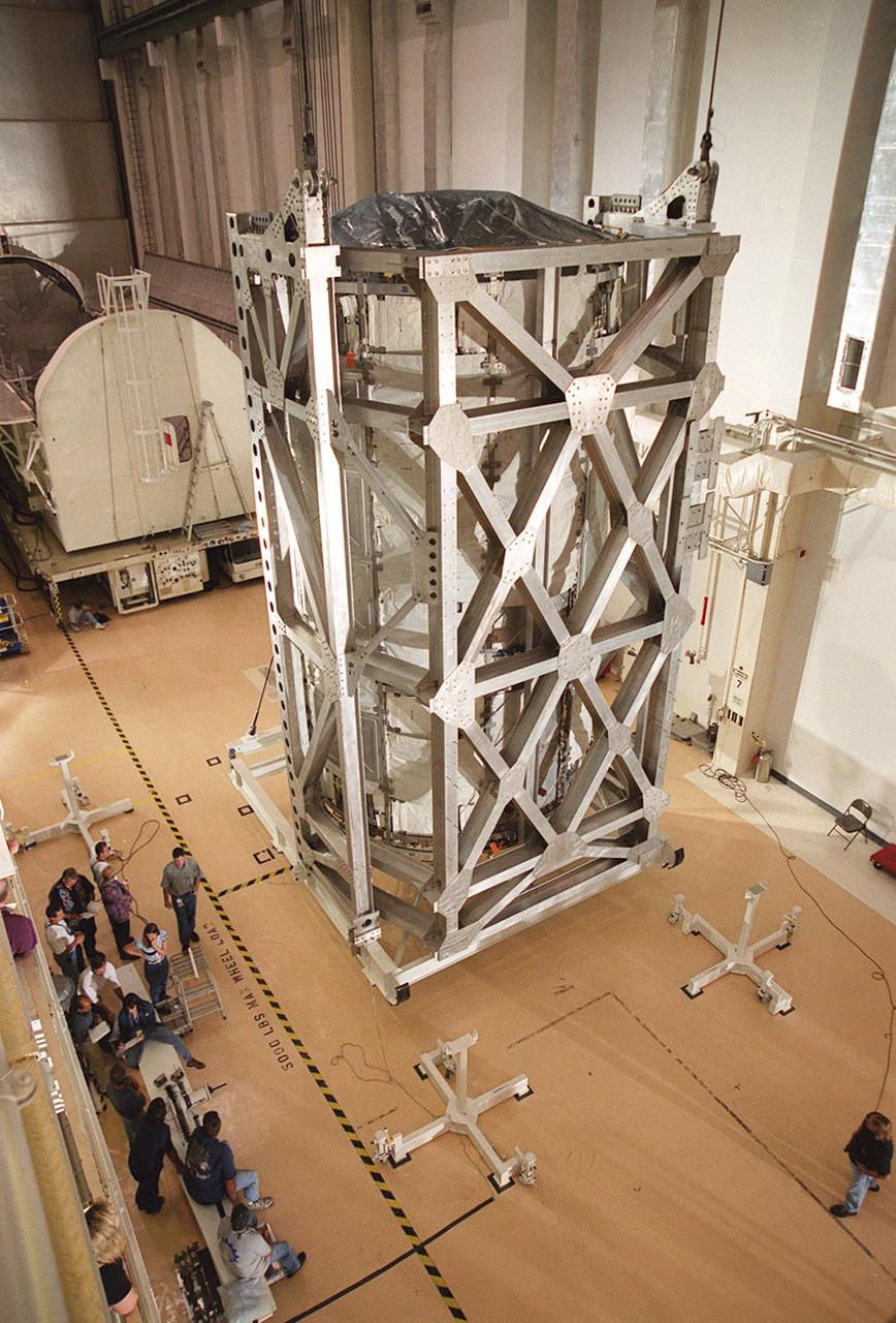 KENNEDY SPACE CENTER, FLA. -- The U.S. Lab, a component of the International Space Station, rests in a vertical position in the Operations and Checkout Building. The Lab, named Destiny, will undergo testing in the altitude chamber in the O&C. Behind the Lab is the payload canister which transported it from the Space Station Processing Facility. Destiny is scheduled to fly on mission STS-98 in early 2001. During the mission, the crew will install the Lab in the Space Station during a series of three space walks. The STS-98 mission will provide the Station with science research facilities and expand its power, life support and control capabilities. The U.S. Lab module continues a long tradition of microgravity materials research, first conducted by Skylab and later Shuttle and Spacelab missions. Destiny is expected to be a major feature in future research, providing facilities for biotechnology, fluid physics, combustion, and life sciences research