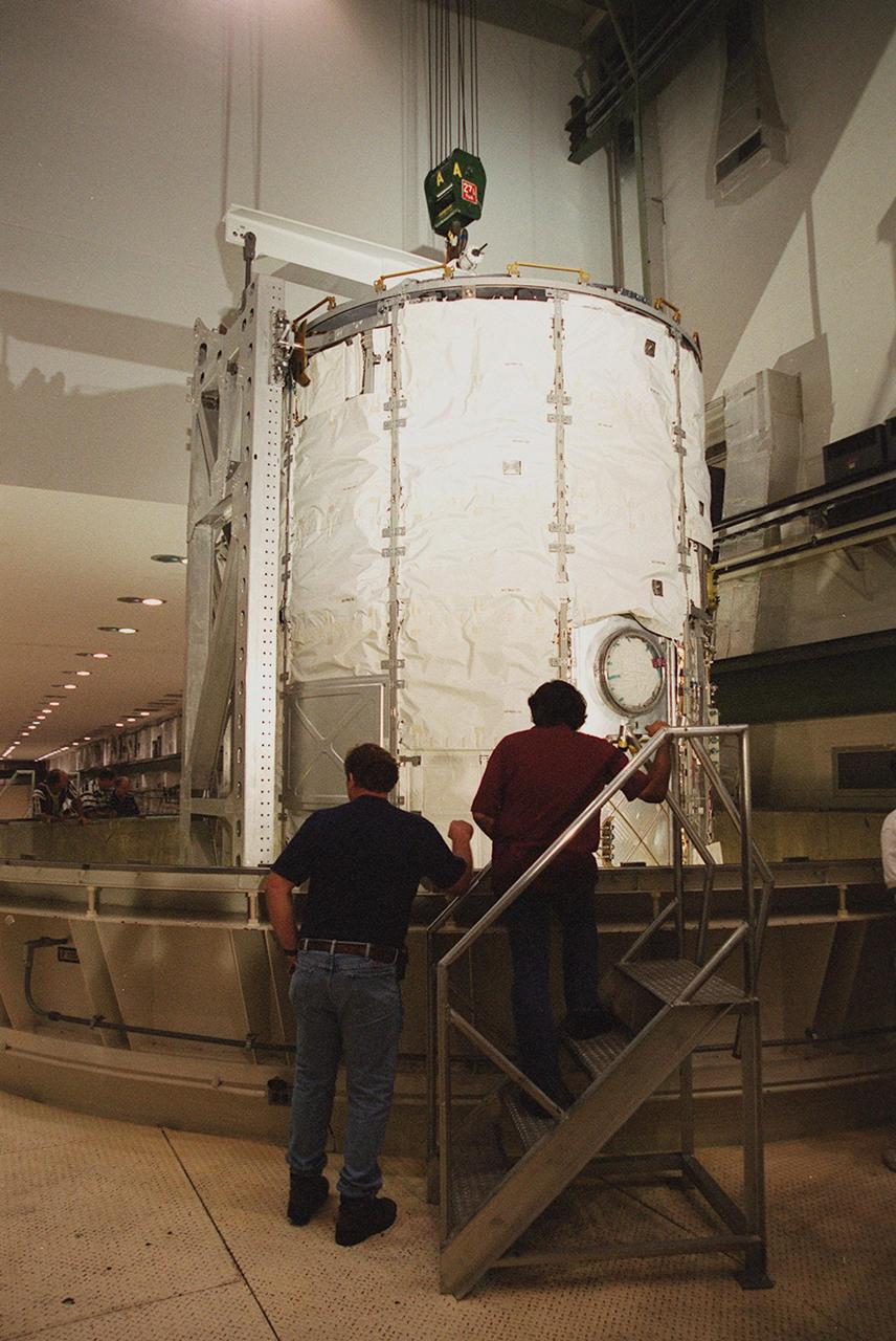 KENNEDY SPACE CENTER, FLA. -- In the Operations and Checkout Building, the U.S. Lab, a component of the International Space Station, is lowered into a three-story vacuum chamber. The 32,000-pound scientific research lab, named Destiny, is the first Space Station element to spend seven days in the renovated vacuum chamber for a leak test. Destiny is scheduled to be launched on Shuttle mission STS-98, the 5A assembly mission, targeted for Jan. 18, 2001. During the mission, the crew will install the Lab in the Space Station during a series of three space walks. The STS-98 mission will provide the Station with science research facilities and expand its power, life support and control capabilities. The U.S. Lab module continues a long tradition of microgravity materials research, first conducted by Skylab and later Shuttle and Spacelab missions. Destiny is expected to be a major feature in future research, providing facilities for biotechnology, fluid physics, combustion, and life sciences research
