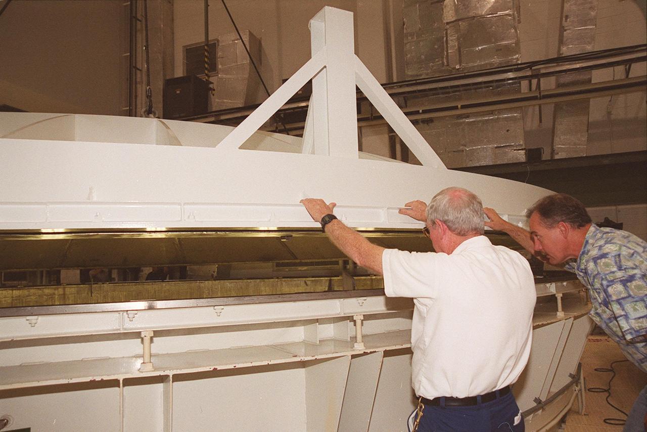 KENNEDY SPACE CENTER, FLA. -- Workers in the Operations and Checkout Building check the placement of the lid on the vacuum chamber containing the U.S. Lab, a component of the International Space Station. The 32,000-pound scientific research lab, named Destiny, is the first Space Station element to spend seven days in the renovated vacuum chamber for a leak test. Destiny is scheduled to be launched on Shuttle mission STS-98, the 5A assembly mission, targeted for Jan. 18, 2001. During the mission, the crew will install the Lab in the Space Station during a series of three space walks. The STS-98 mission will provide the Station with science research facilities and expand its power, life support and control capabilities. The U.S. Lab module continues a long tradition of microgravity materials research, first conducted by Skylab and later Shuttle and Spacelab missions. Destiny is expected to be a major feature in future research, providing facilities for biotechnology, fluid physics, combustion, and life sciences research