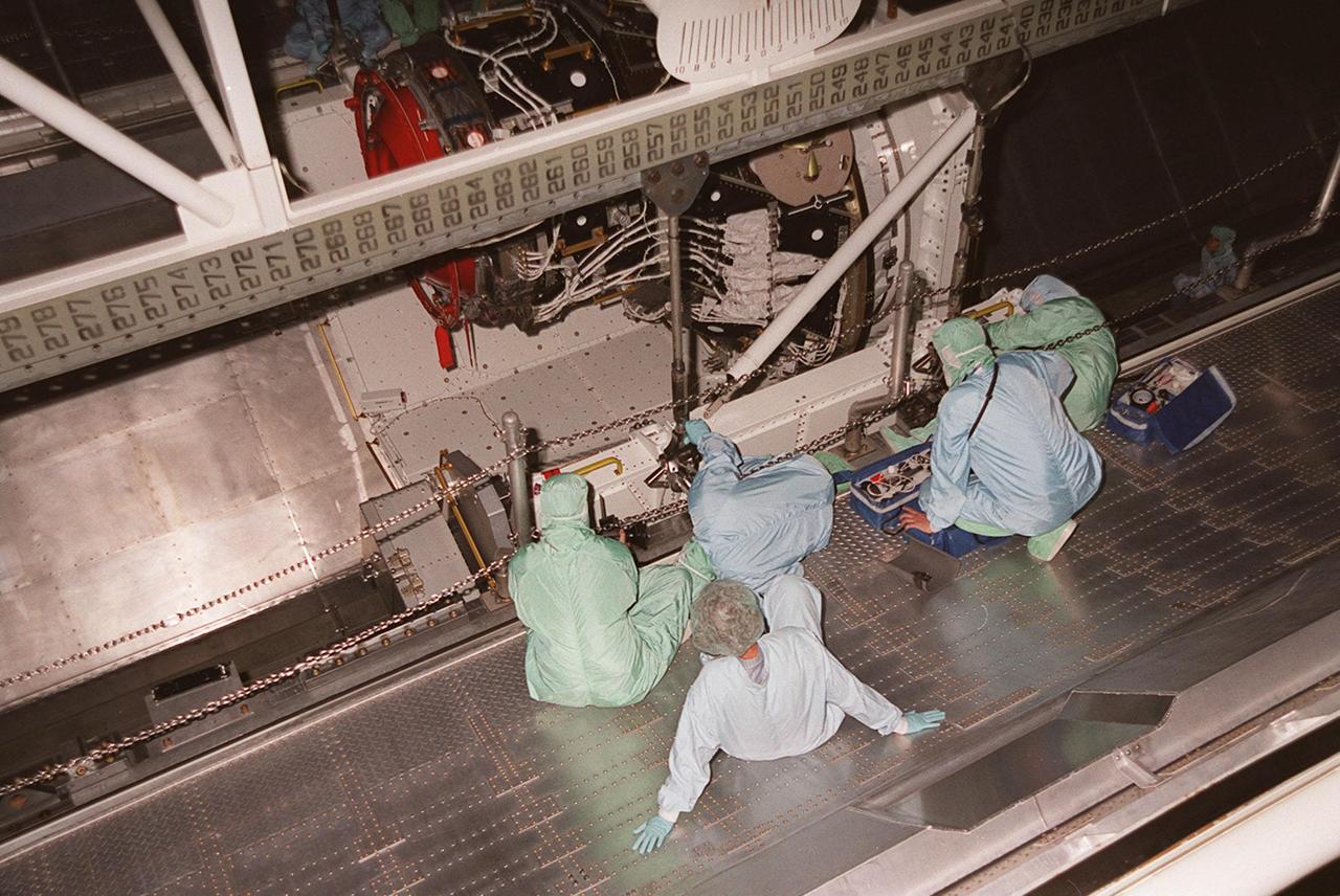 KENNEDY SPACE CENTER, FLA. -- Workers in the Orbiter Processing Facility check the placement of cables on the Pressurized Mating Adapter -3 (PMA-3) for its transfer to the orbiter Discovery. A component of the International Space Station, the PMA-3 is part of the payload on Space Shuttle mission STS-92, scheduled to launch Oct. 5. The mission will be the fifth flight to the Space Station, and the 100th Shuttle flight overall. PMA-3 provides shuttle docking port for solar array installation on flight 4A (mission STS-97 scheduled for Nov. 30), and Lab installation on flight 5A (mission STS-98, scheduled for Jan. 18, 2001)