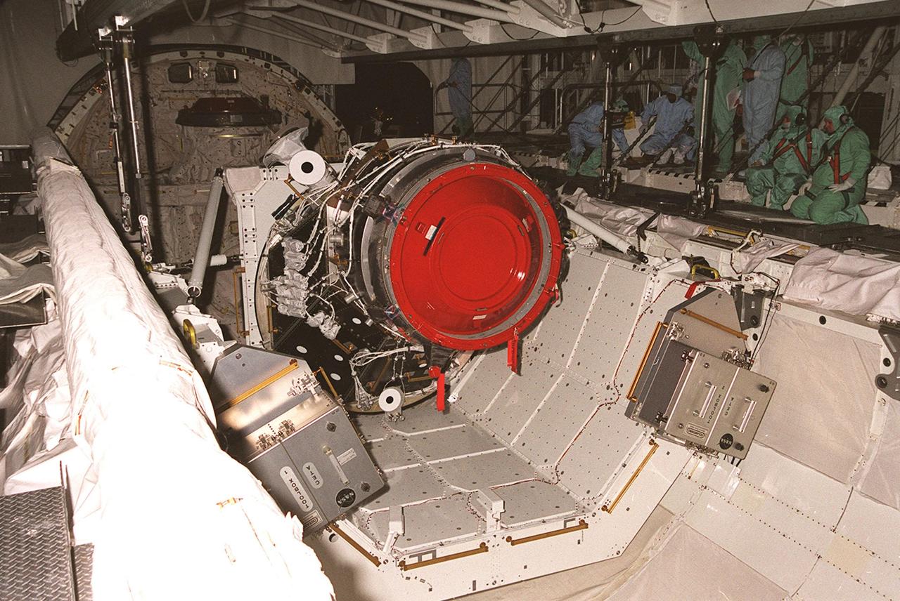 KENNEDY SPACE CENTER, FLA. -- In the Orbiter Processing Facility bay 1, workers detach the overhead crane from the Pressurized Mating Adapter -3 (PMA-3), which sits in the payload bay of the orbiter Discovery. A component of the International Space Station, the PMA-3 will fly on Shuttle mission STS-92, scheduled to launch Oct. 5. The mission will be the fifth flight to the Space Station, and the 100th Shuttle flight overall. PMA-3 provides shuttle docking port for solar array installation on flight 4A (mission STS-97 scheduled for Nov. 30), and Lab installation on flight 5A (mission STS-98, scheduled for Jan. 18, 2001)