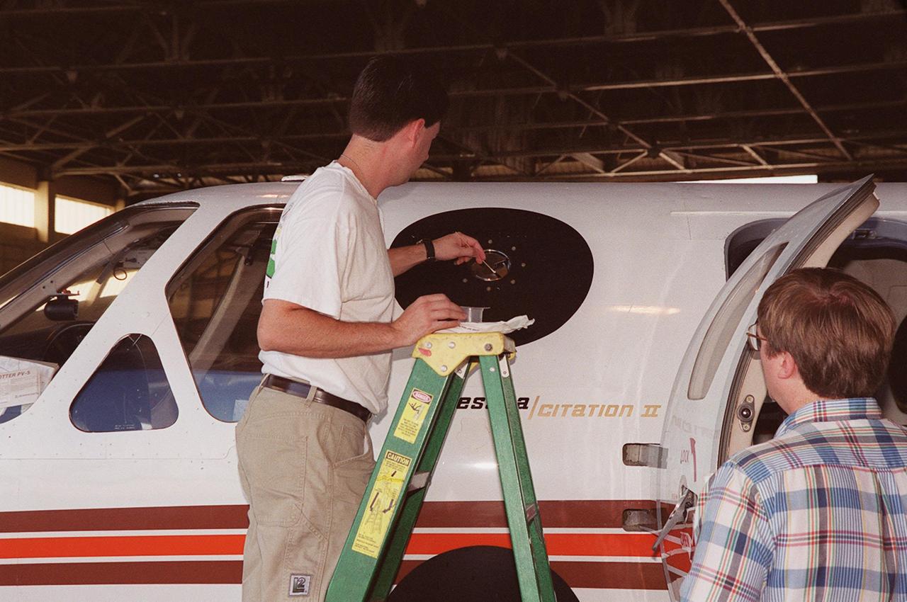 In a hangar at Cape Canaveral Air Force Station, a weather researcher checks a field mill measuring device on the Cessna Citation. The aircraft is being used for NASA’s airborne field mill study. The plane also carries cloud physics probes (under the body and wings) that measure the size, shape and number of ice and water particles in clouds. The plane is being flown into anvil clouds in the KSC area as part of a study to review and possibly modify lightning launch commit criteria. The weather study could lead to improved lightning avoidance rules and fewer launch scrubs for the Space Shuttle and other launch vehicles on the Eastern and Western ranges.; More information about the study can be found in <a href="http://www-pao.ksc.nasa.gov/kscpao/release/2000/56-00.htm">Release No. 56-00</a>
