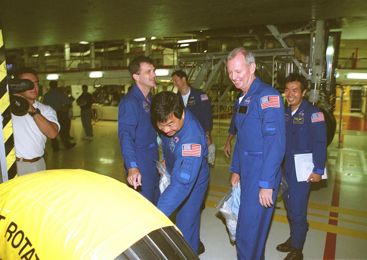 KENNEDY SPACE CENTER, FLA. -- Members of the STS-92 crew look over a tire on the landing gear of orbiter Discovery in the Orbiter Processing Facility bay 1. From left to right are Mission Specialists Jeff Wisoff (pointing) and Leroy Chiao, Commander Brian Duffy and Mission Specialist Koichi Wakata, who is with the Japanese space agency. Standing behind them is Mission Specialist Michael Lopez-Alegria. The crew is at KSC to take part in Crew Equipment Interface Test activities. Others taking part are Pilot Pam Melroy and Mission Specialist Bill McArthur. STS-92 is scheduled to launch Oct. 5 on Shuttle Discovery from Launch Pad 39A on the fifth flight to the International Space Station. Discovery will carry the Integrated Truss Structure (ITS) Z1, Pressurized Mating Adapter 3 (PMA-3), Ku-band Communications System, and Control Moment Gyros (CMGs)