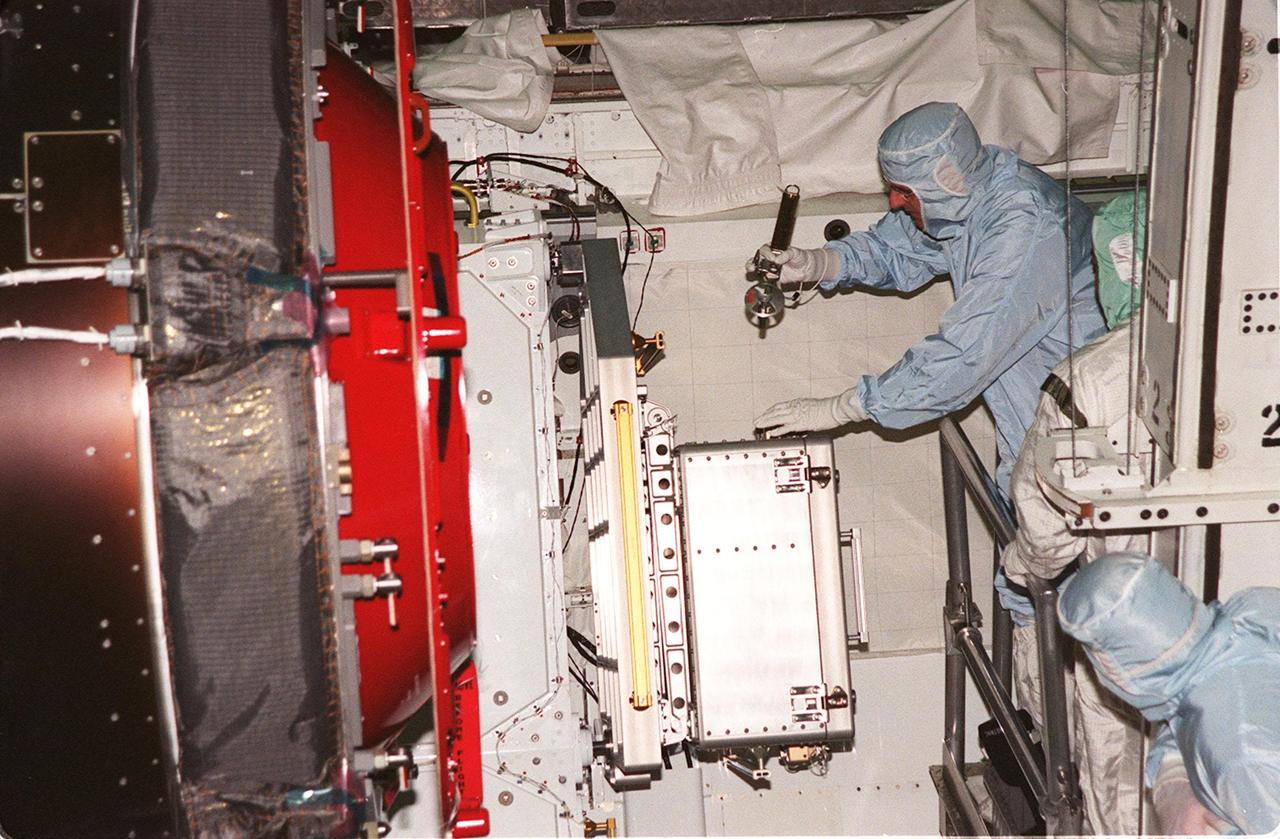 KENNEDY SPACE CENTER, FLA. -- STS-92 Mission Specialist Bill McArthur (with tool in hand) gets a close look at the Pressurized Mating Adapter-3 in the payload bay of orbiter Discovery. He and other crew members Commander Brian Duffy, Pilot Pam Melroy and Mission Specialists Koichi Wakata, Leroy Chiao, Jeff Wisoff, and Michael Lopez-Alegria are at KSC to take part in Crew Equipment Interface Test activities. Discovery is in the Orbiter Processing Facility bay 1. STS-92 is scheduled to launch Oct. 5 on Shuttle Discovery from Launch Pad 39A on the fifth flight to the International Space Station. Discovery will carry the Integrated Truss Structure (ITS) Z1, the PMA-3, Ku-band Communications System, and Control Moment Gyros (CMGs)
