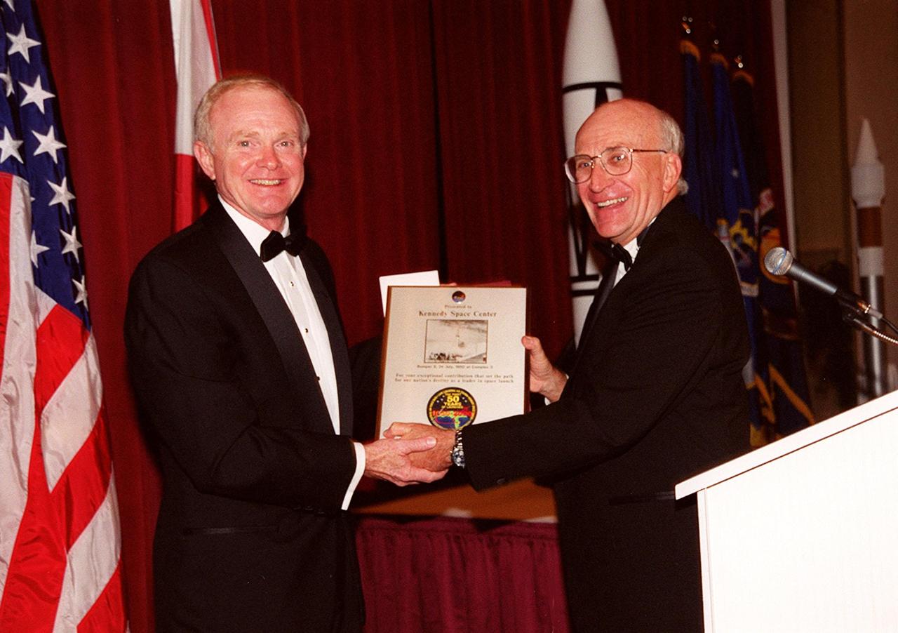 At a 50th anniversary gala capping a year-long celebration of 50 years of launches from Cape Canaveral Air Force Station, Center Director Roy Bridges (left) receives a plaque from committee chairman Ed Gormel. The plaque has a photo of the first rocket launch from Cape Canaveral Air Force Station (CCAFSj) and an anniversary patch below it that was flown on STS-99. The first launch at CCAFS took place at 9:28 a.m. on July 24, 1950, with the liftoff of Bumper 8 from Launch Complex 3. The gala, hosted by the Cape Canaveral Chapter Air Force Association, featured such speakers as Center Director Roy Bridges; Vice Commander, Air Force Space Command, Lt. Gen. Roger DeKok; and the Honorable David Weldon, U.S. representative of Florida’s 15th Congressional District