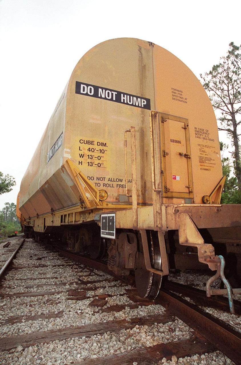 One of two solid rocket booster rail cars is off the track after being involved in a minor derailment incident during a routine movement on the tracks. The rail cars were being moved as part of a standard operation to “order” the cars, placing them into a proper sequence for upcoming segment processing activities. The rear wheels of one car and the front wheels of the car behind it slid off the tracks while passing through a railway switch onto a siding. They were traveling approximately 3 miles per hour at the time, about normal walking speed. No damage occurred to the SRB segments, or to the devices that secure the segments to the rail cars. The incident occurred on KSC property, just north of the NASA Causeway in the KSC Industrial Area