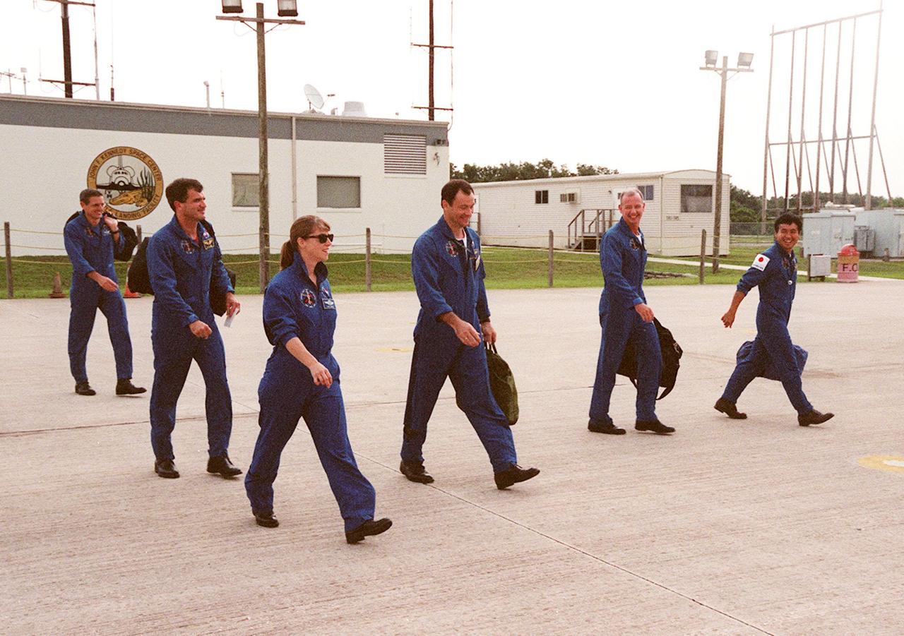 The STS-92 crew strides across the runway at KSC’s Shuttle Landing Facility, heading toward the aircraft that will take them back to Houston. They were at KSC for Crew Equipment Interface Test (CEIT) activities, looking over their mission payload and related equipment. From left are Mission Specialists Bill McArthur and Jeff Wisoff, Pilot Pam Melroy, Mission Specialist Michael Lopez-Alegria, Commander Brian Duffy and Mission Specialist Koichi Wakata, who is with the Japanese space agency. Not seen is Mission Specialist Leroy Chiao, who was also at KSC for the CEIT. STS-92 is scheduled to launch Oct. 5 on Shuttle Discovery from Launch Pad 39A on the fifth flight to the International Space Station. Discovery will carry the Integrated Truss Structure (ITS) Z1, the PMA-3, Ku-band Communications System, and Control Moment Gyros (CMGs)