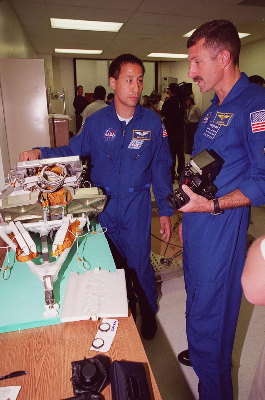 KENNEDY SPACE CENTER, FLA. -- STS-106 Mission Specialists Edward T. Lu (left) and Daniel C. Burbank examine equipment at SPACEHAB, part of the payload on the mission to the International Space Station. They and the other crew members Commander Terrence W. Wilcutt, Pilot Scott D. Altman, and Mission Specialists Yuri I. Malenchenko, Boris V. Morukov and Richard A. Mastracchio are taking part in Crew Equipment Interface Test (CEIT) activities at SPACEHAB. Malenchenko and Morukov represent the Russian Aviation and Space Agency. On the 11-day mission, the seven-member crew will perform support tasks on orbit, transfer supplies and prepare the living quarters in the newly arrived Zvezda Service Module for the first long-duration crew, dubbed "Expedition One," which is due to arrive at the Station in late fall. STS-106 is scheduled to launch Sept. 8, 2000, at 8:31 a.m. EDT from Launch Pad 39B