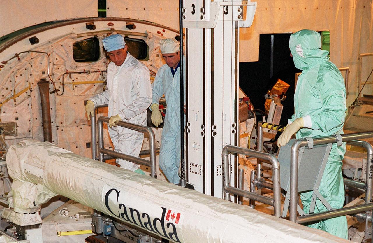 In Orbiter Processing Facility bay 3, STS-106 Mission Specialists Edward T. Lu (left) and Yuri I. Malenchenko (center) familiarize themselves with equipment in the payload bay of Space Shuttle orbiter Atlantis with the help of KSC employees as part of Crew Equipment Interface Test (CEIT) activities for their mission. The other crew members are Commander Terrence W. Wilcutt, Pilot Scott D. Altman, and Mission Specialists Daniel C. Burbank, Boris V. Morukov and Richard A. Mastracchio. Malenchenko and Morukov represent the Russian Aviation and Space Agency. On the 11-day mission, the seven-member crew will perform support tasks on orbit, transfer supplies and prepare the living quarters in the newly arrived Zvezda Service Module for the first long-duration crew, dubbed "Expedition One," which is due to arrive at the Station in late fall. STS-106 is scheduled to launch Sept. 8, 2000, at 8:31 a.m. EDT from Launch Pad 39B